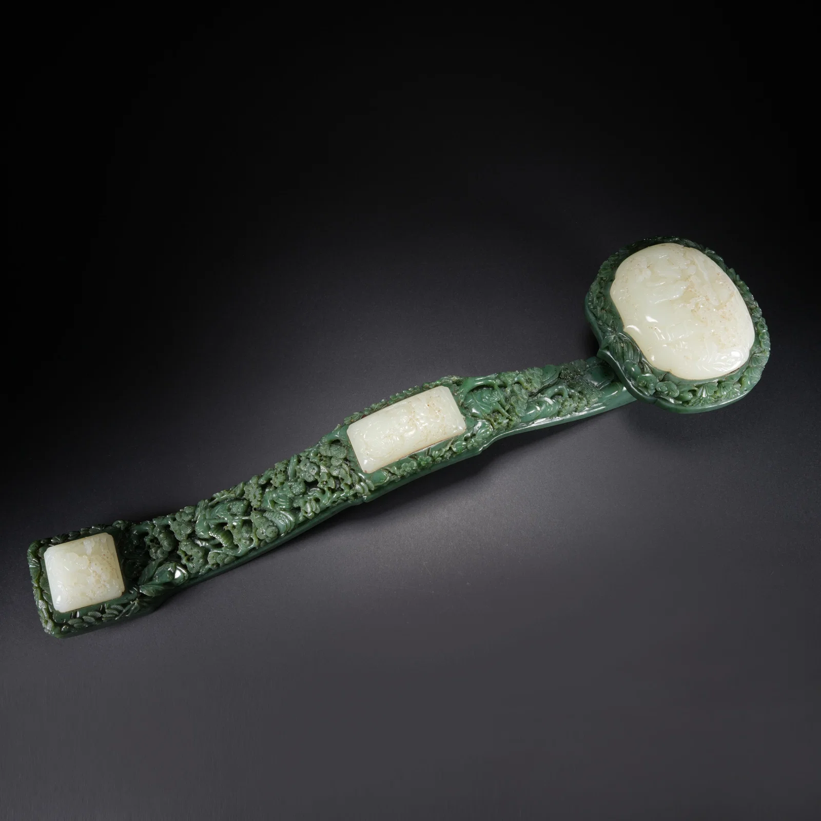 A HETIAN SPINACH GREEN JADE INLAID HETIAN JADE CARVED RUYI WITH FIGURAL NARRATIVE MOTIF