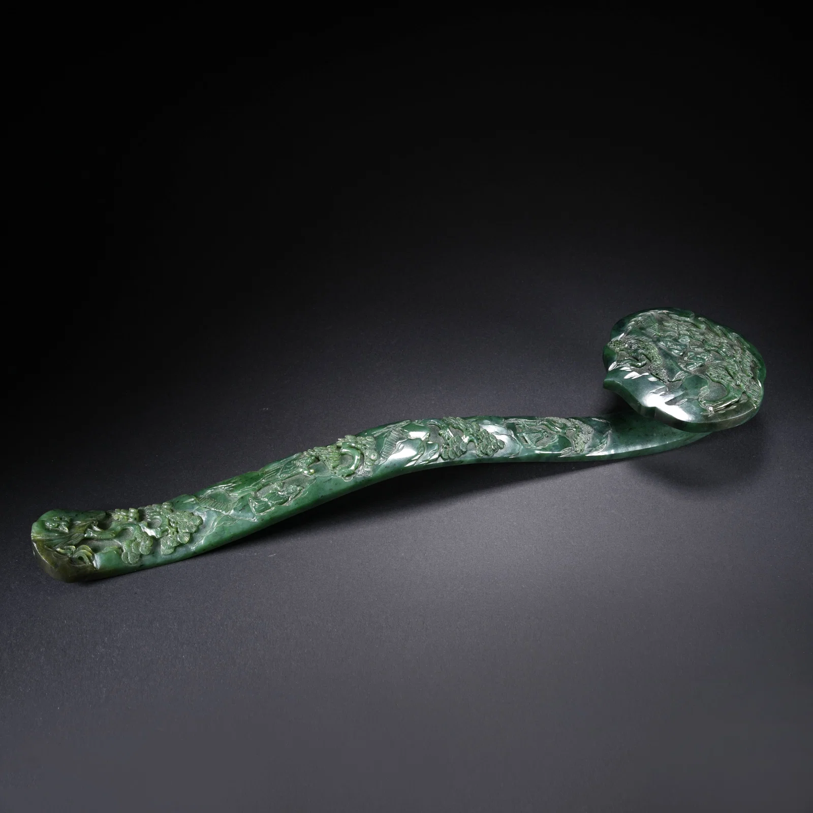 A HETIAN SPINACH GREEN JADE RUYI WITH LANDSCAPE AND FIGURAL MOTIF