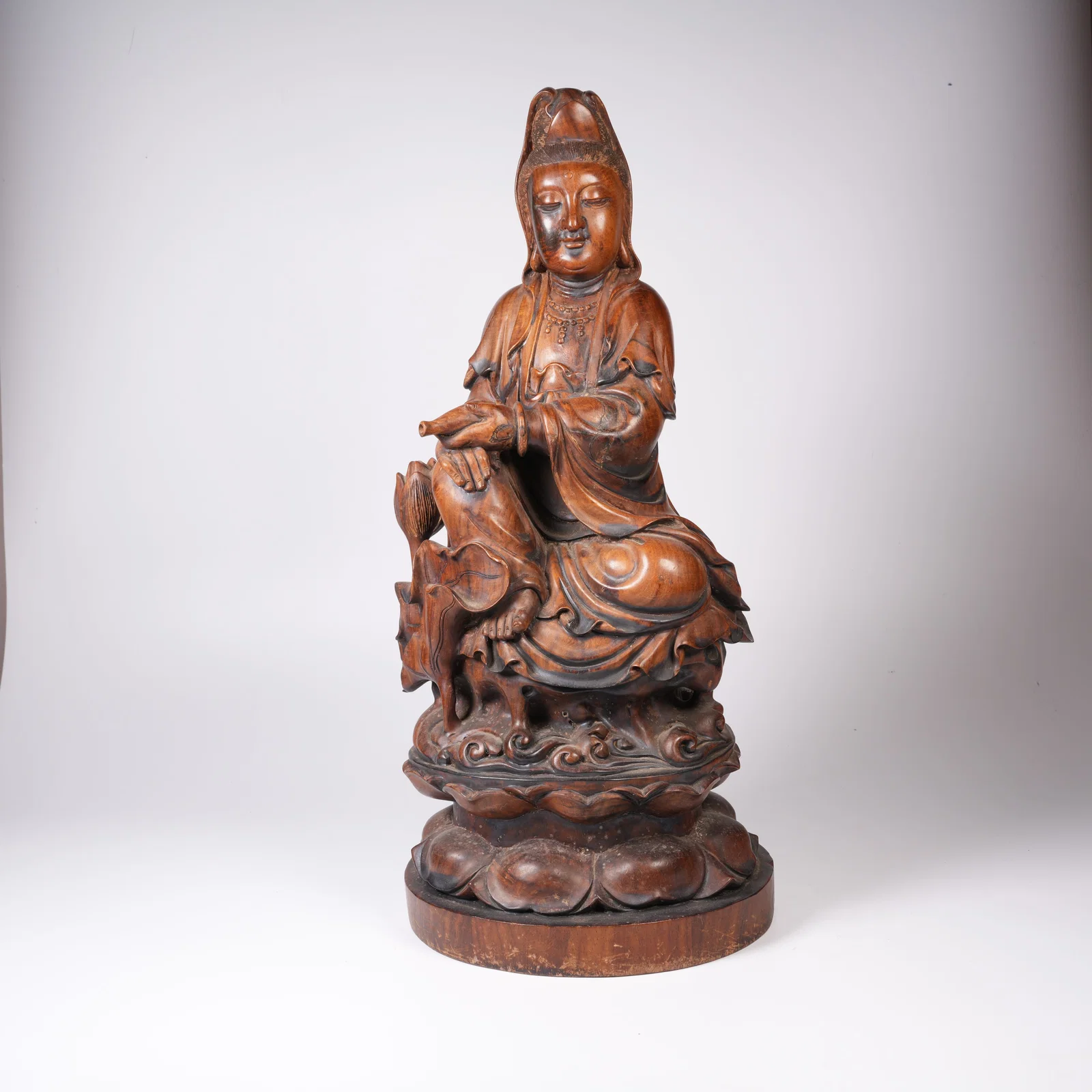 A HUANGHUALI WOOD GUANYIN STATUE IN A CLEAN VASE FORM
