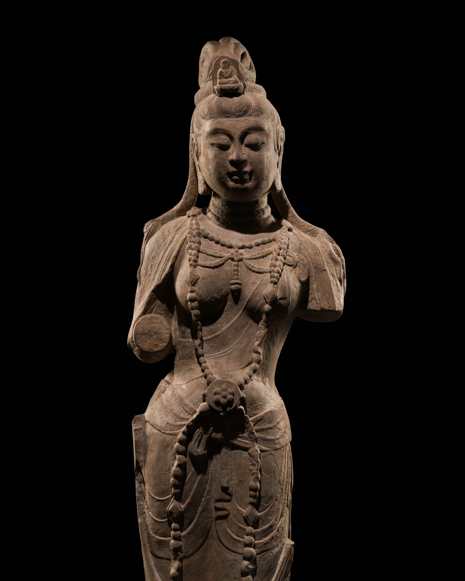 A LARGE AND IMPORTANT ROSE SANDSTONE FIGURE OF GUANYIN, TANG DYNASTY, PROBABLY FROM THE TIANLONGSHAN