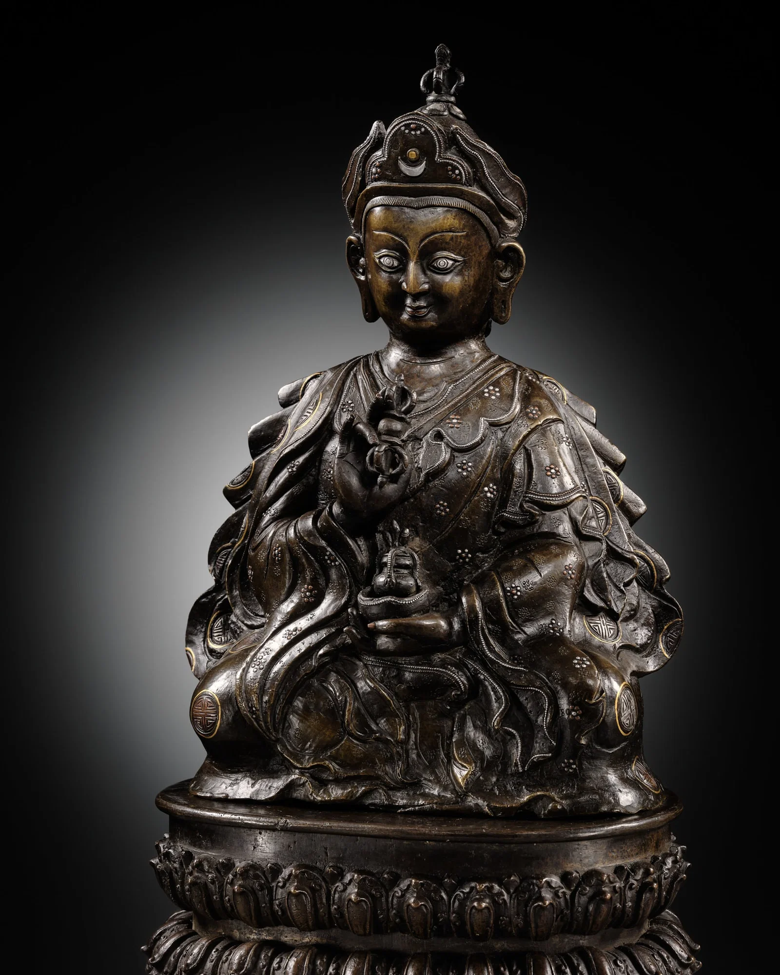 A LARGE GOLD, SILVER, AND COPPER INLAID BRONZE FIGURE OF PADMASAMBHAVA, 17TH-18TH CENTURY