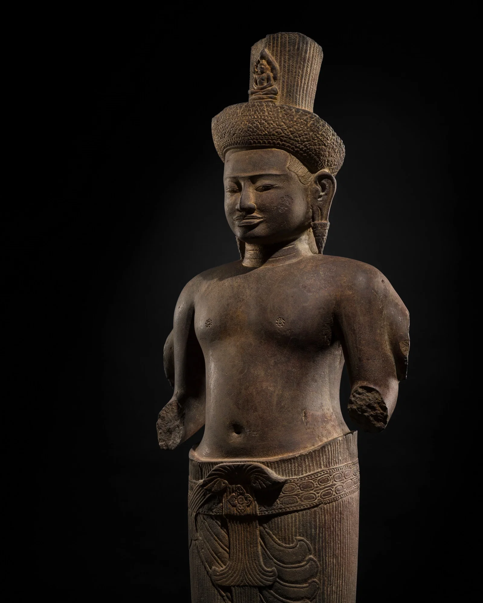 A LARGE SANDSTONE FIGURE OF AVALOKITESHVARA, ANGKOR PERIOD, ANGKOR WAT STYLE, 12TH CENTURY