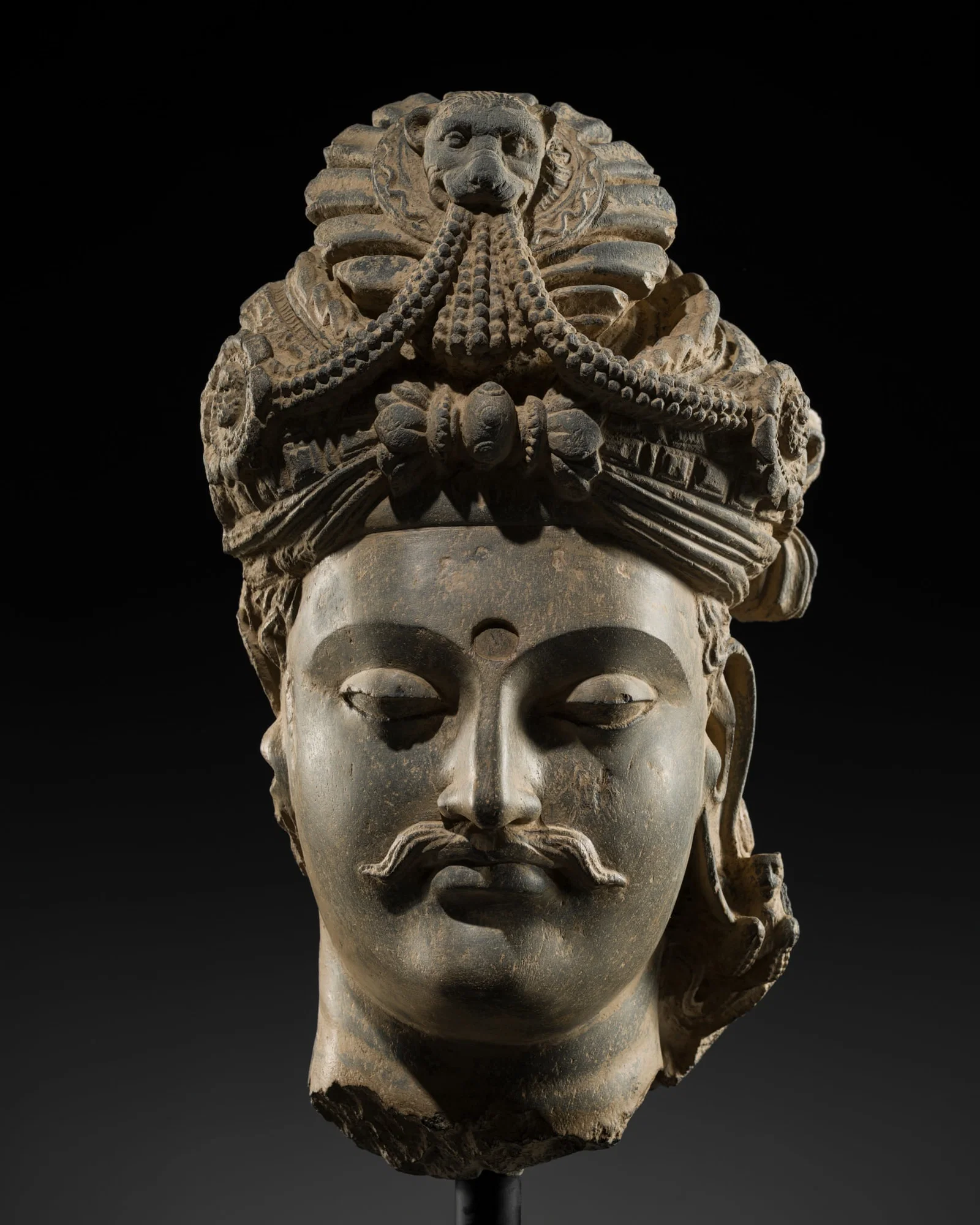 A LARGE SCHIST HEAD OF A BODHISATTVA WITH A 'KĪRTIMUKHA' TURBAN, GANDHARA, 4TH-5TH CENTURY,