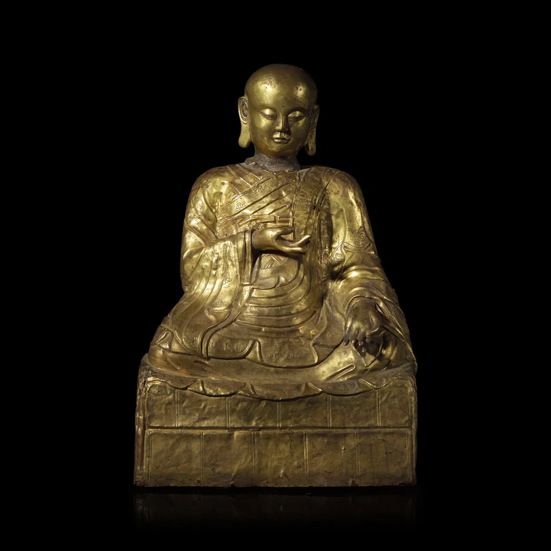 A Mongolian Gilt Copper Repoussé Figure of a Seated Luohan or Monk, 19th Century 清