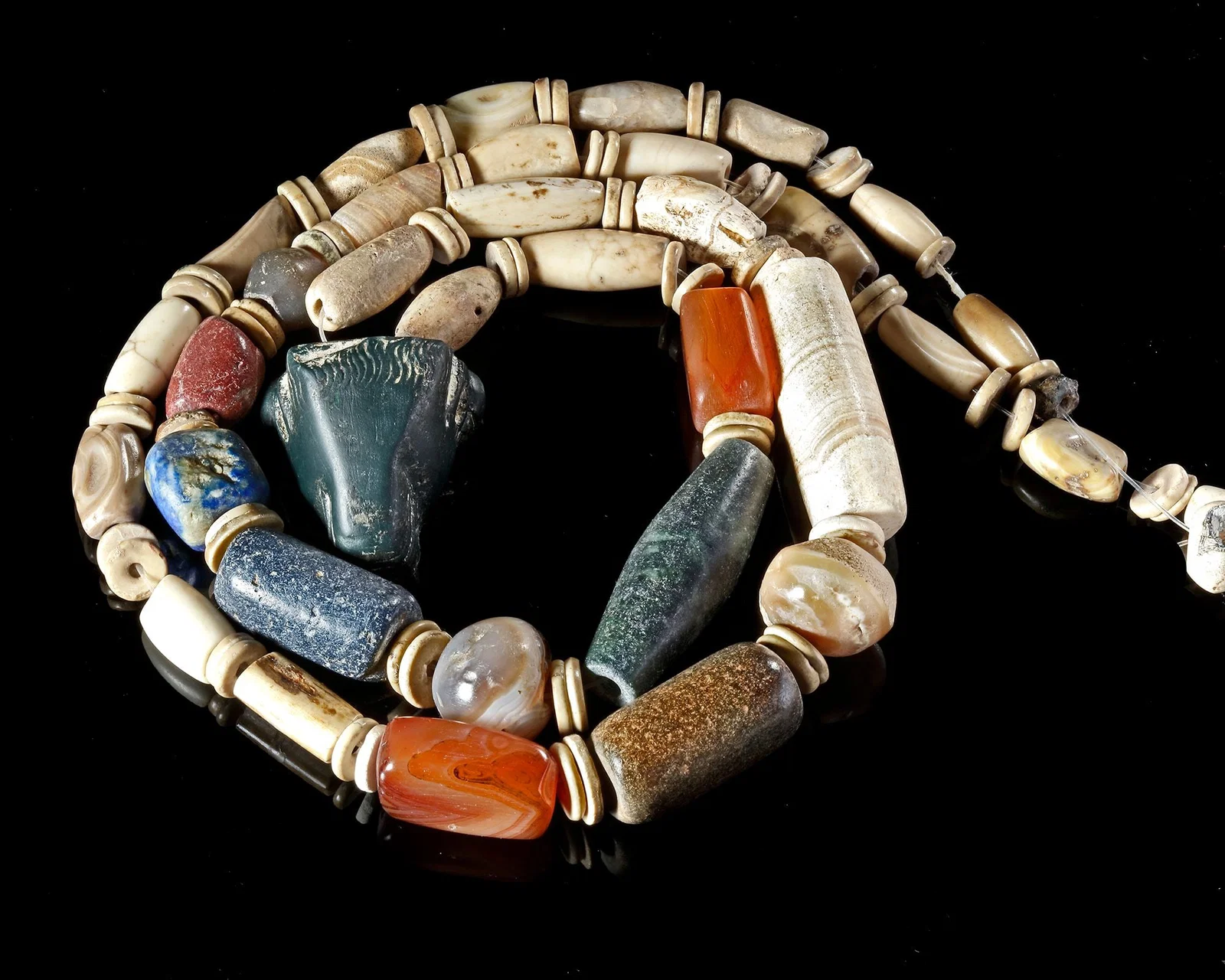 A NECKLACE OF BEADS WITH BULL HEAD PENDANT, 2ND-3RD MILLENNIUM BC
