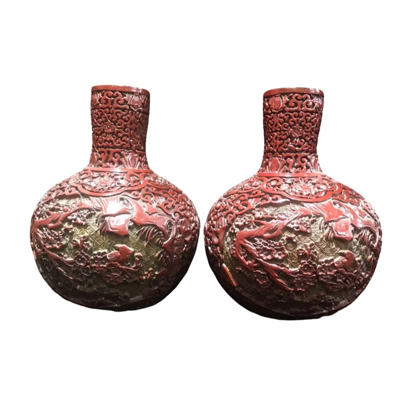 A pair of antique Tibetan carved lacquerware vases with floral and bird motifs.