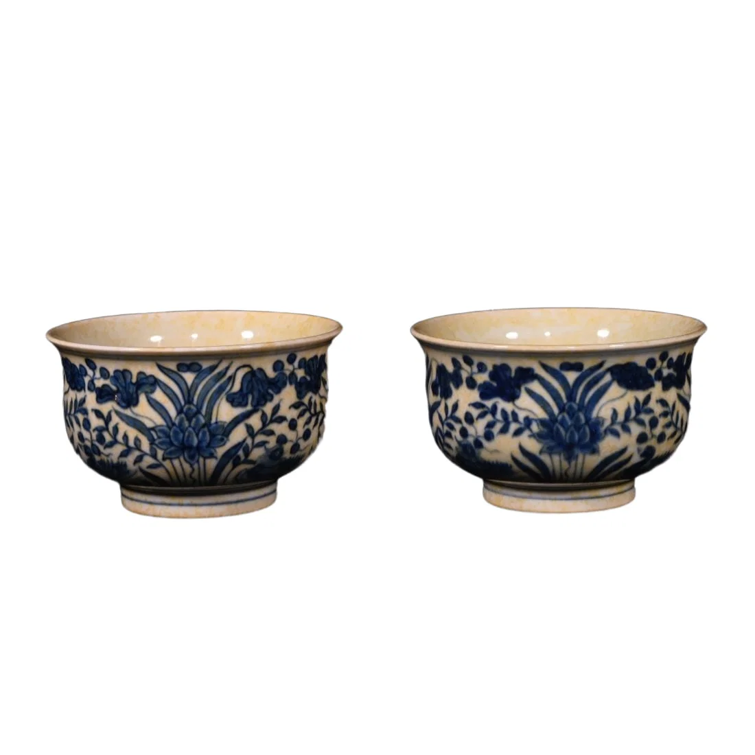A pair of blue and white cups with mandarin ducks playing in the water