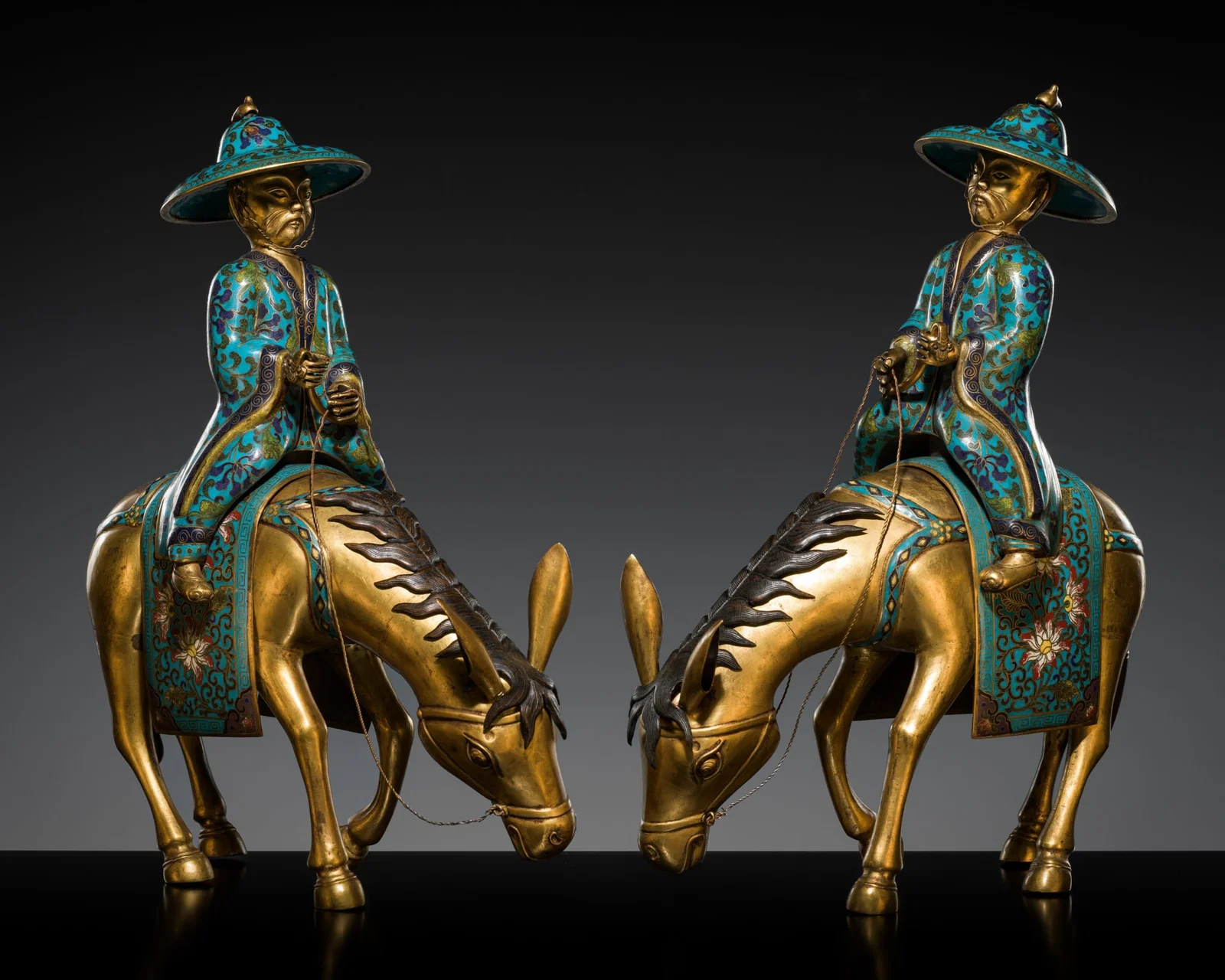 A PAIR OF GILT-BRONZE CLOISONNE ENAMEL RIDERS ON MULES, QING DYNASTY