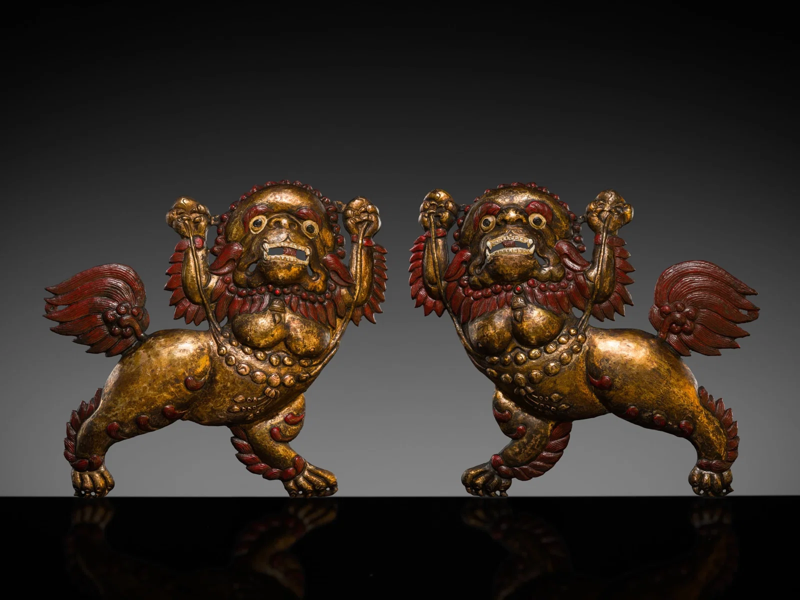 A PAIR OF GILT COPPER REPOUSSÉ SNOW LIONS, TIBET, 17TH-18TH CENTURY