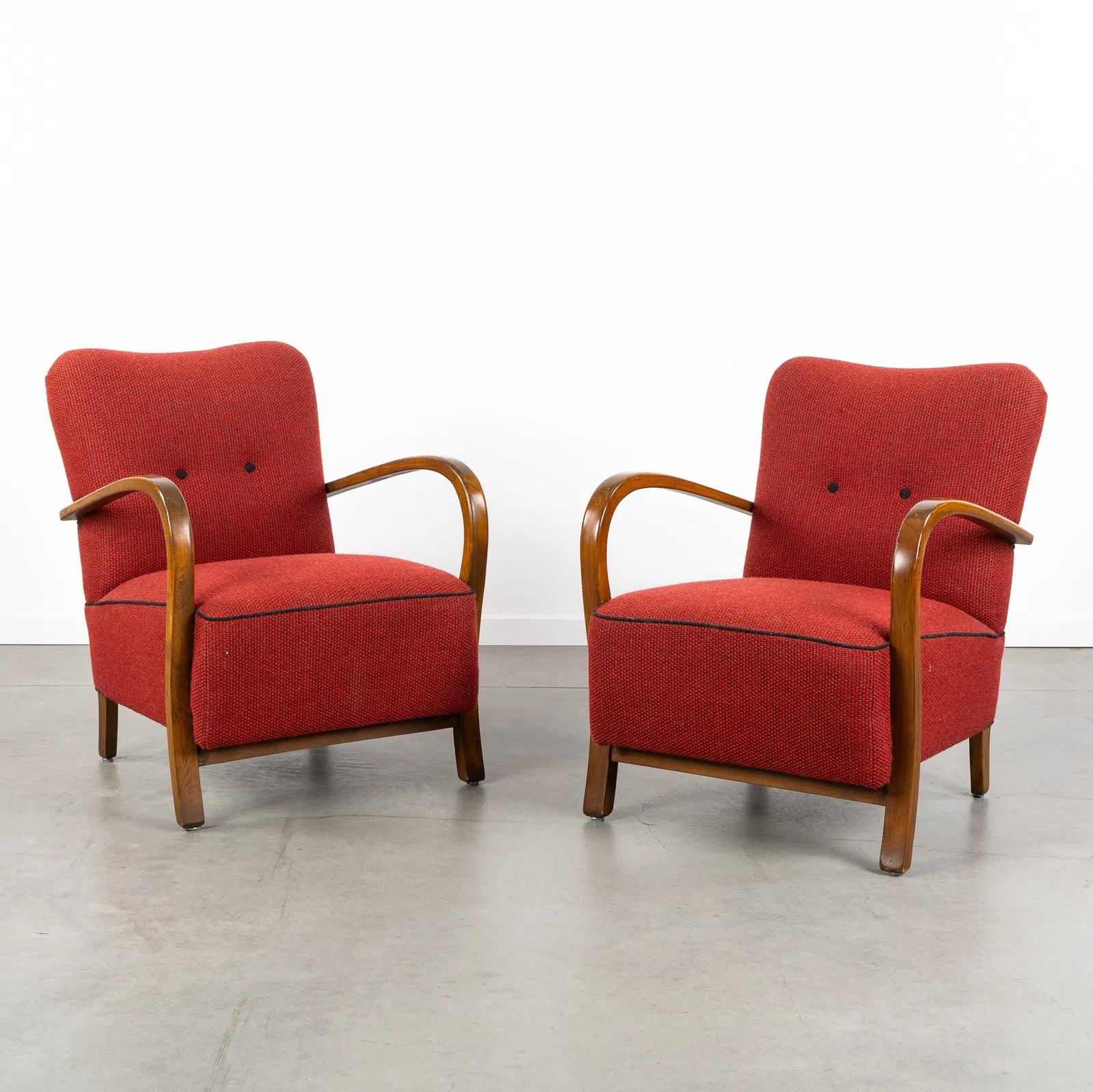 A Pair of red upholstered armchairs, Art Deco style, in the style of Halabala and Kozelka &