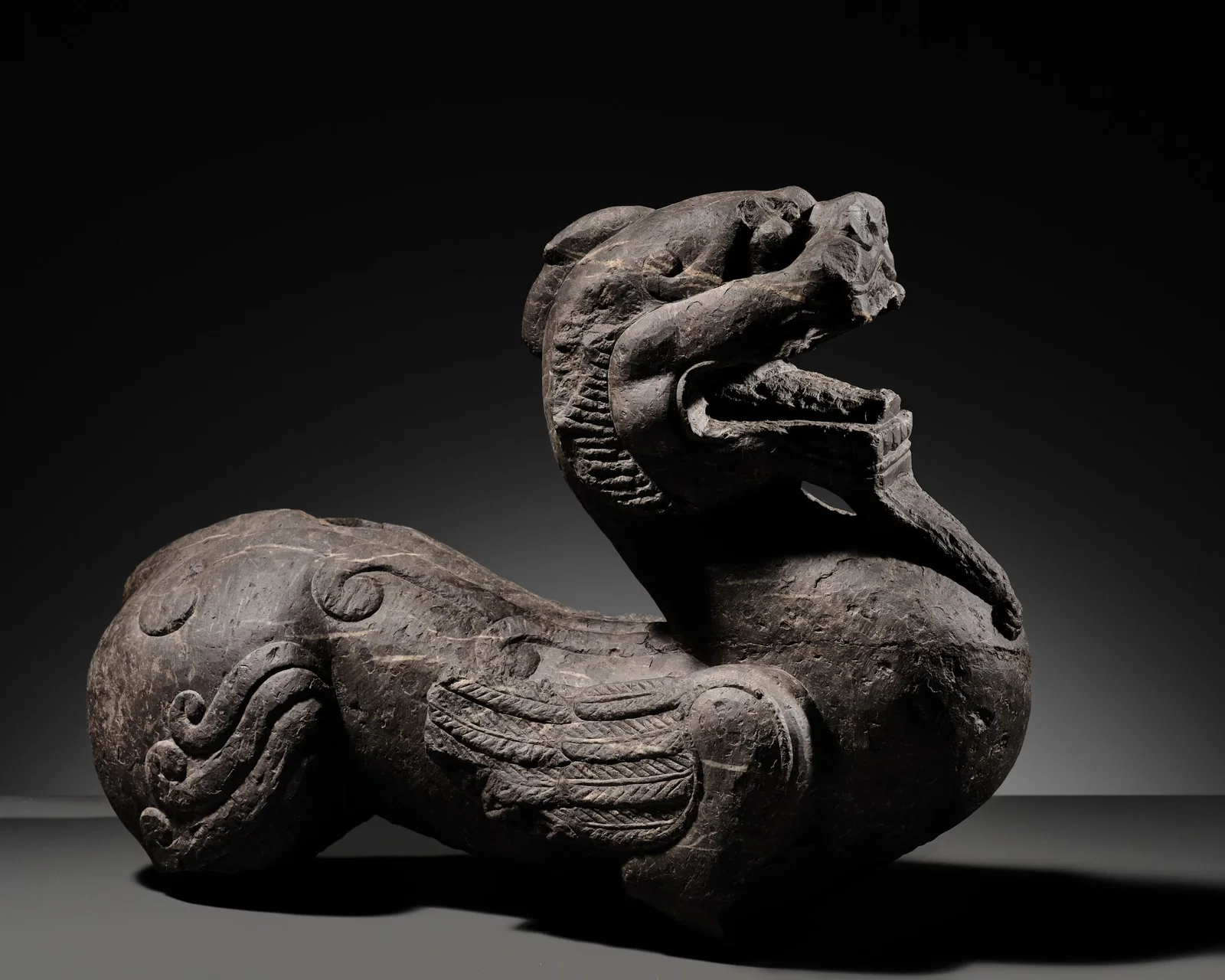 A POWERFUL AND IMPORTANT LIMESTONE FIGURE OF A BIXIE, SIX DYNASTIES PERIOD