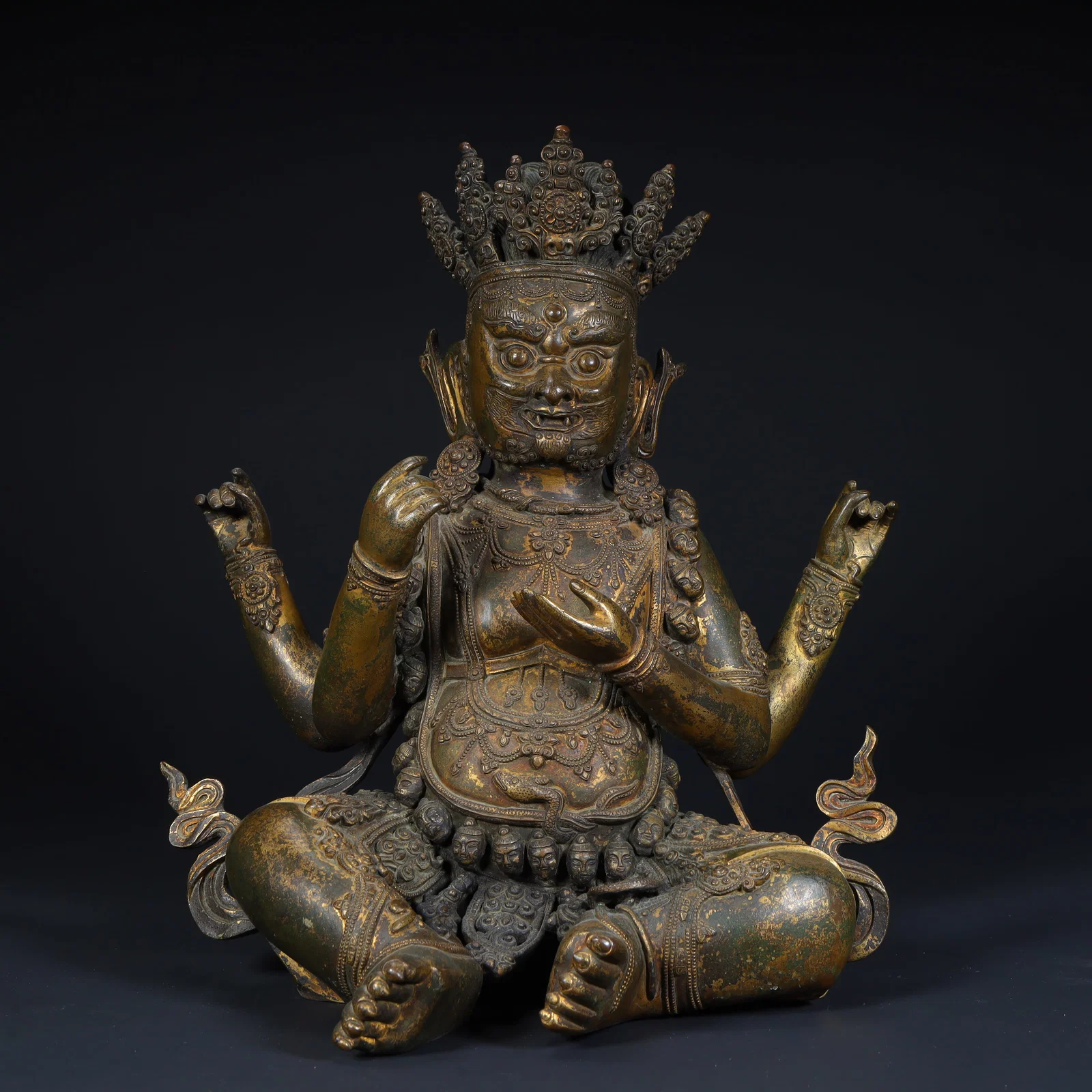 A Qing Dynasty copper gilt four-armed black sky statue