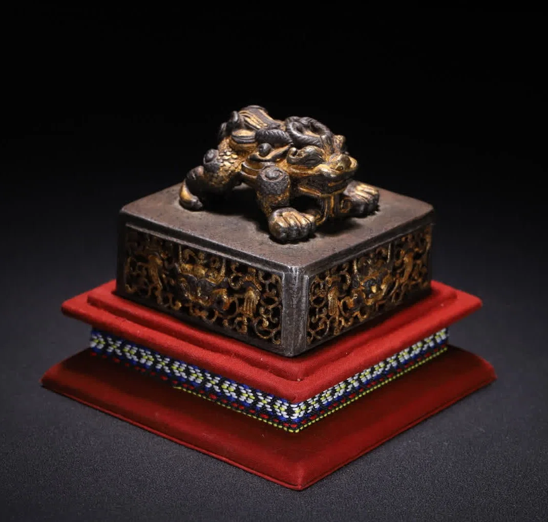 A Qing Dynasty iron-cut gold hollow auspicious beast button stick bazaar seal