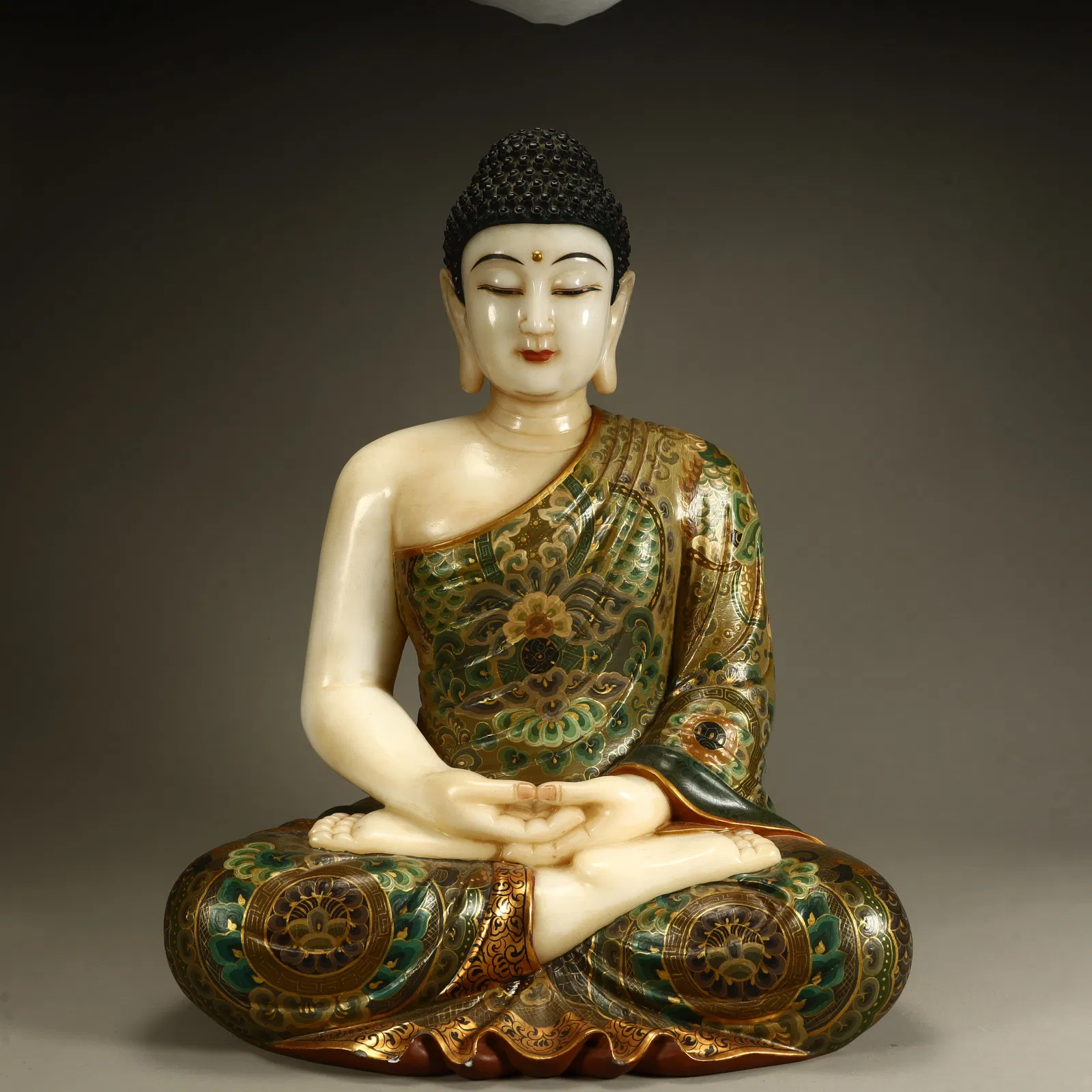 A Qing Dynasty white jade depicting Shakyamuni Buddha statue
