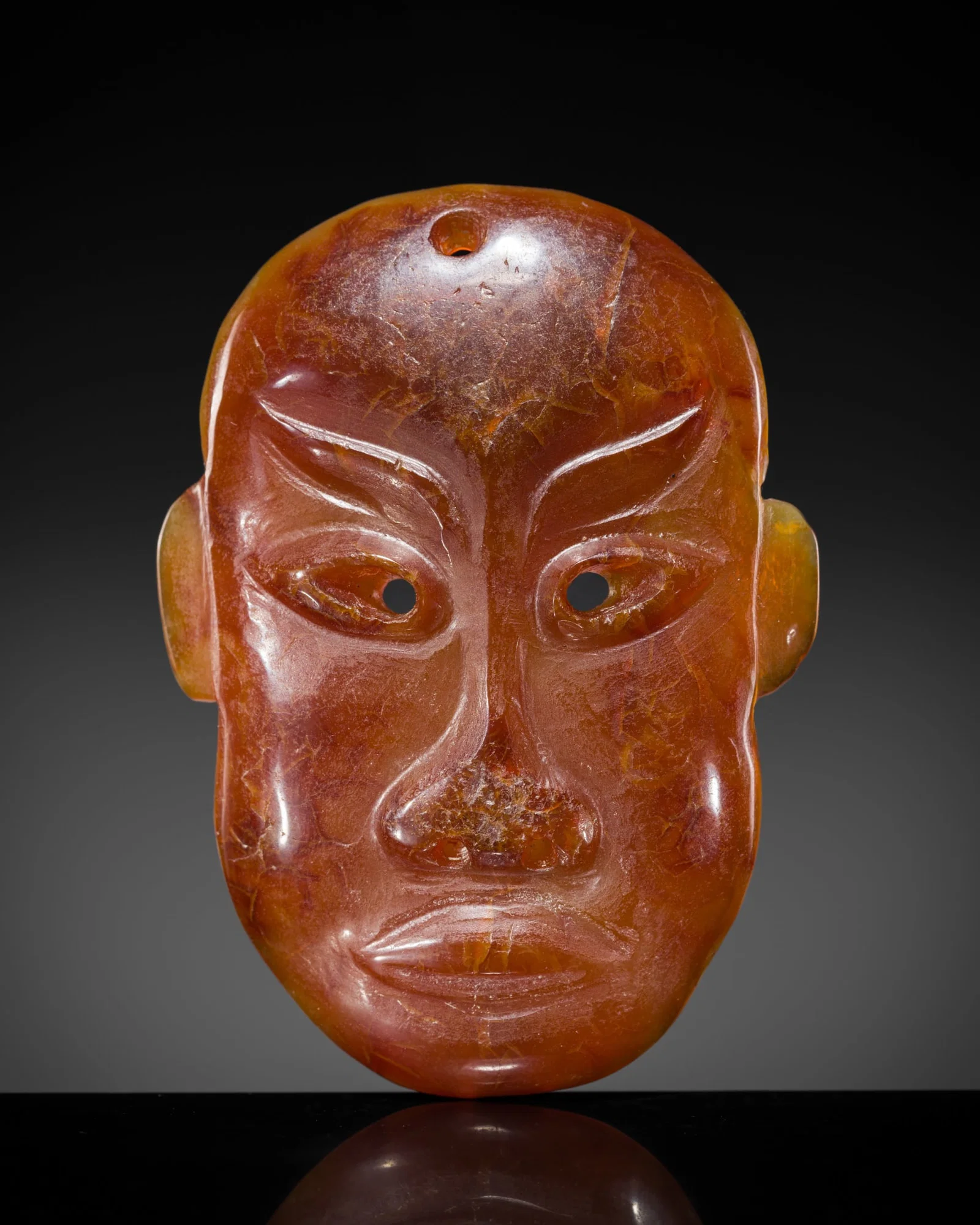 A RARE AGATE 'PORTRAIT MASK' PENDANT, LIAO DYNASTY