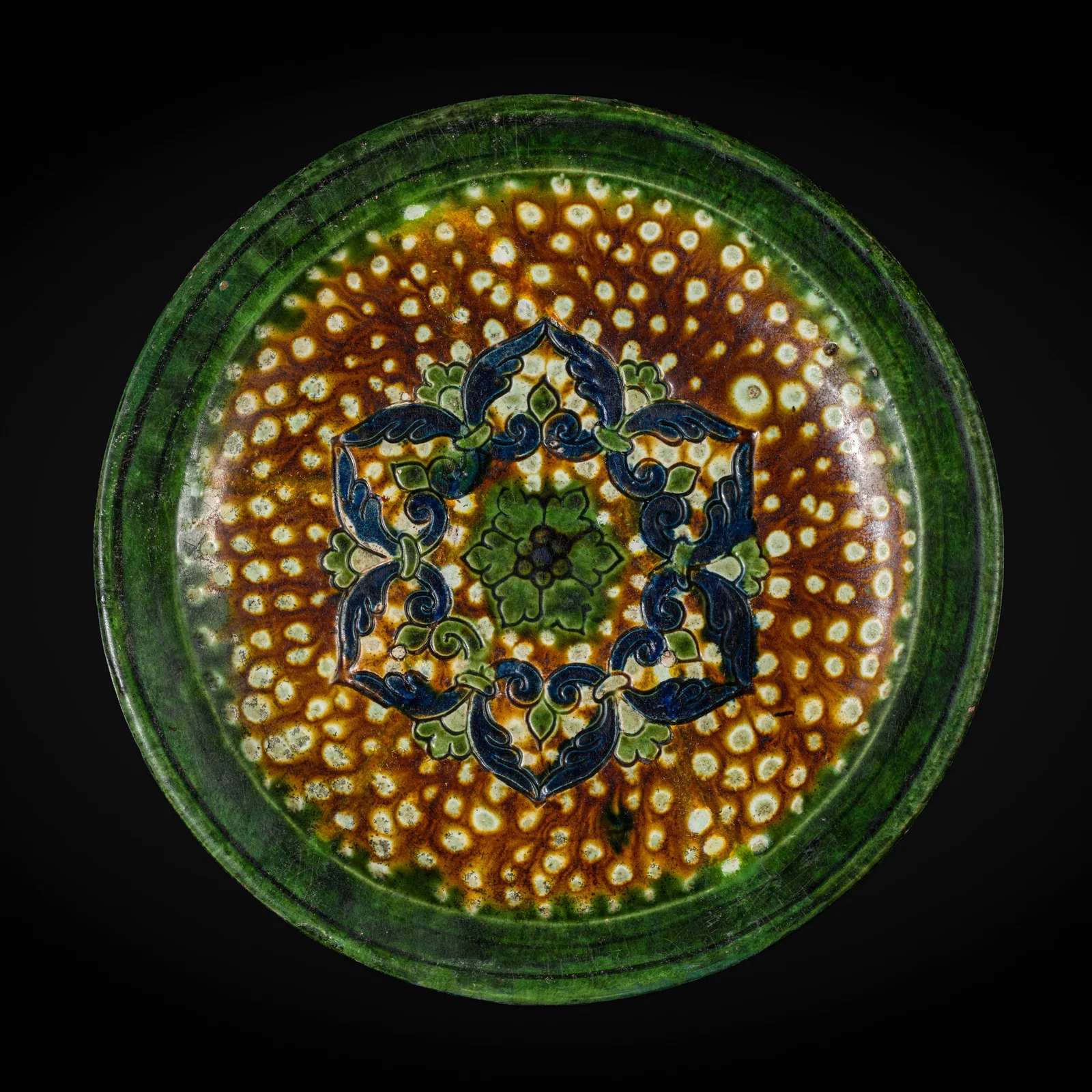 A RARE BLUE AND SANCAI GLAZED 'FLORAL' TRIPOD DISH, TANG DYNASTY