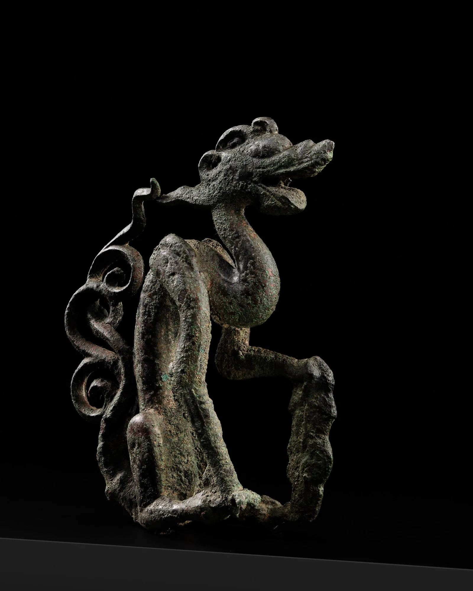 A RARE BRONZE FIGURE OF A SEATED DRAGON, JIN DYNASTY