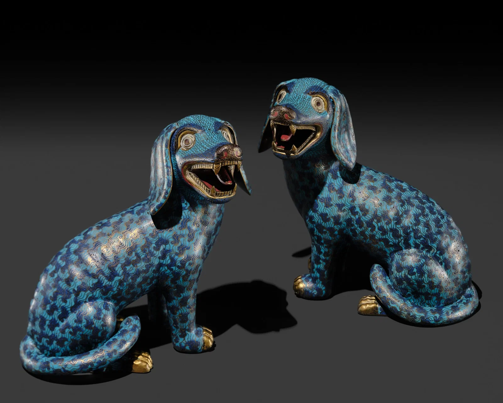 A RARE PAIR OF CLOISONNÉ ENAMEL FIGURES OF SEATED HOUNDS, 18TH CENTURY