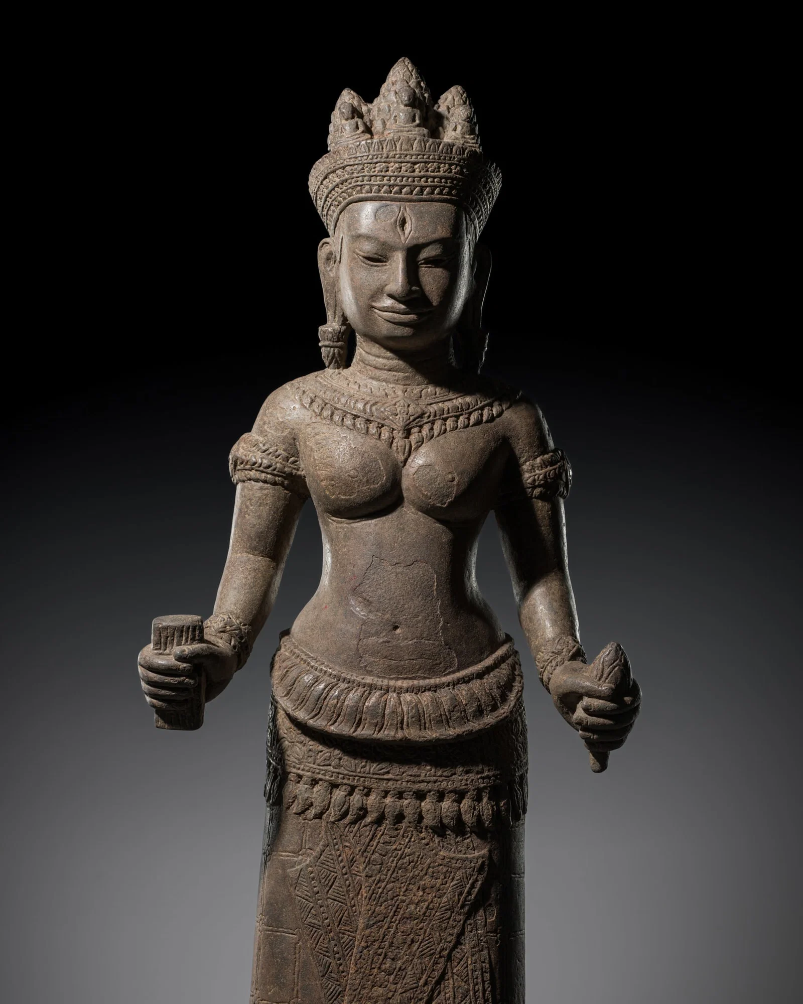 A RARE SANDSTONE FIGURE OF PRAJNAPARAMITA WEARING A 'THREE BUDDHA' CROWN, ANGKOR PERIOD, BAYON