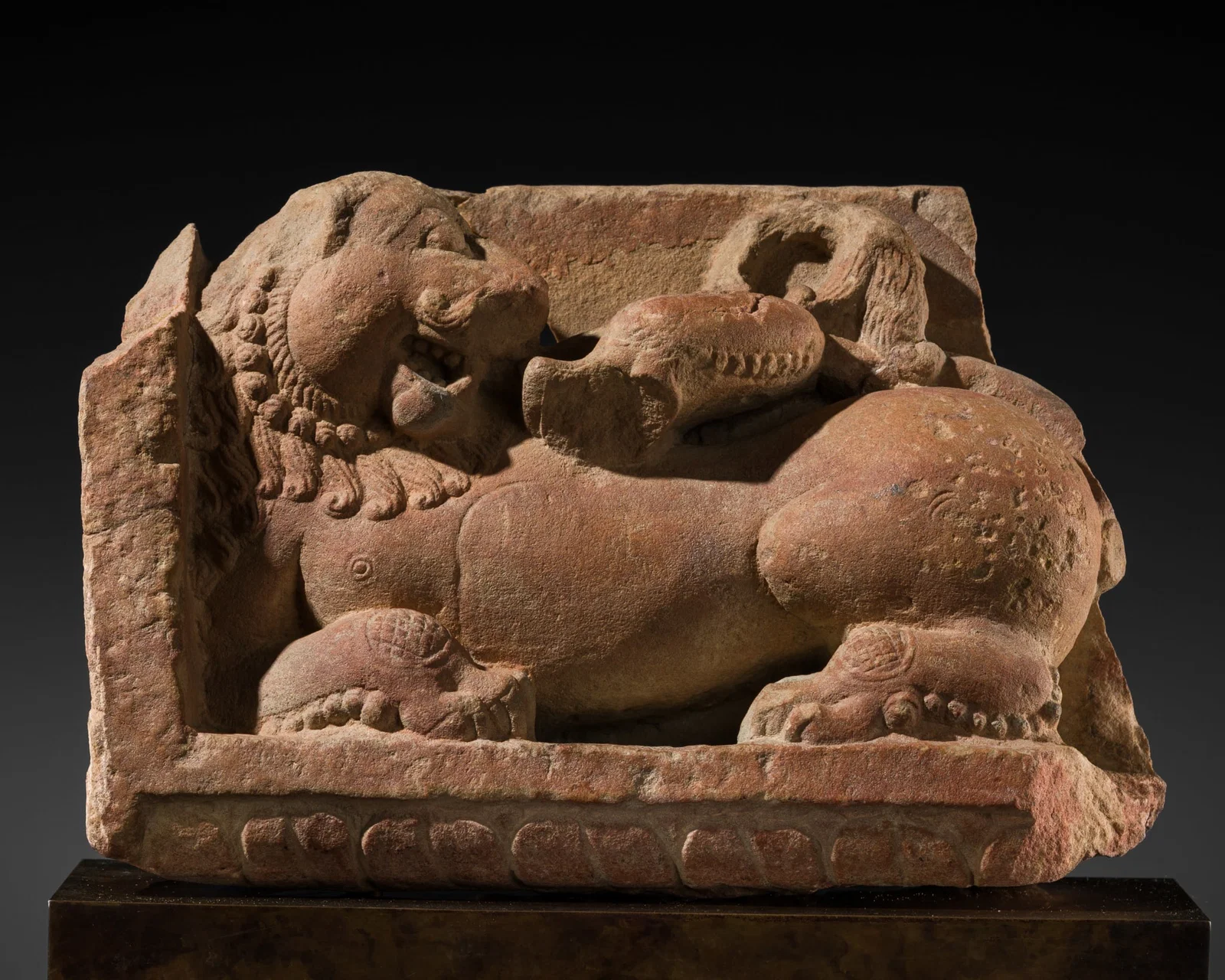 A RED SANDSTONE FIGURE OF A GUARDIAN LION, RAJASTHAN OR UTTAR PRADESH, 8TH-9TH CENTURY