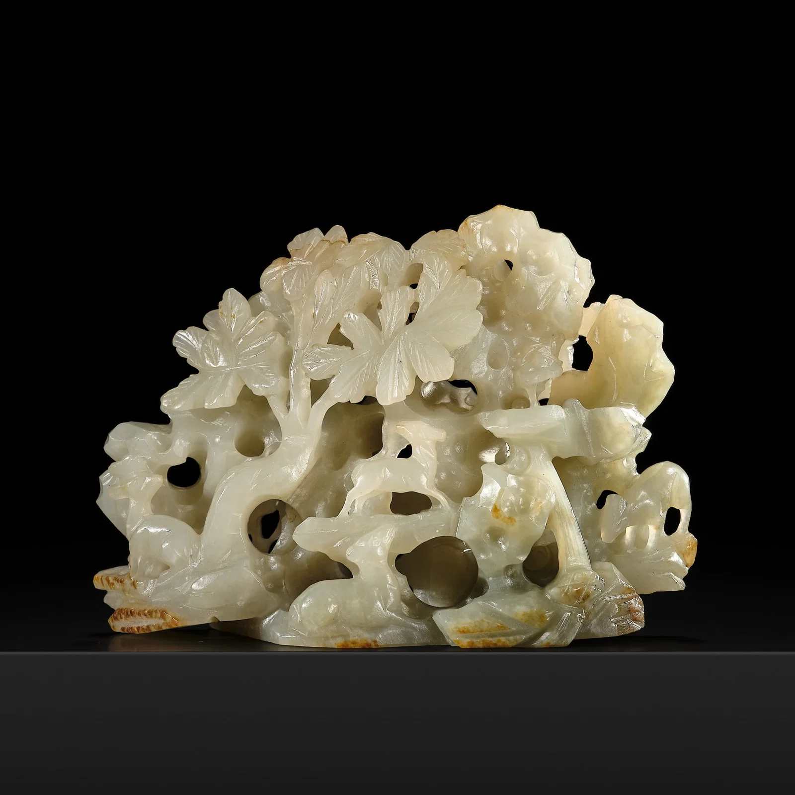 A RETICULATED CELADON AND RUSSET JADE 'ROCK, DEER, AND LINGZHI' GROUP, SONG-YUAN DYNASTY