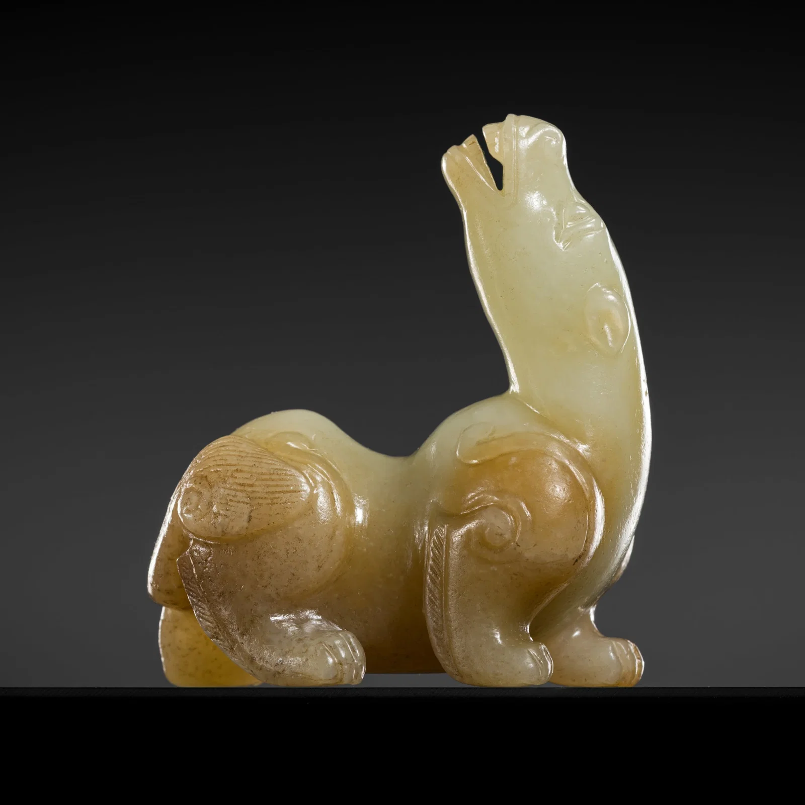 A RUSSET AND CELADON JADE FIGURE OF A MYTHICAL BEAST, MING DYNASTY