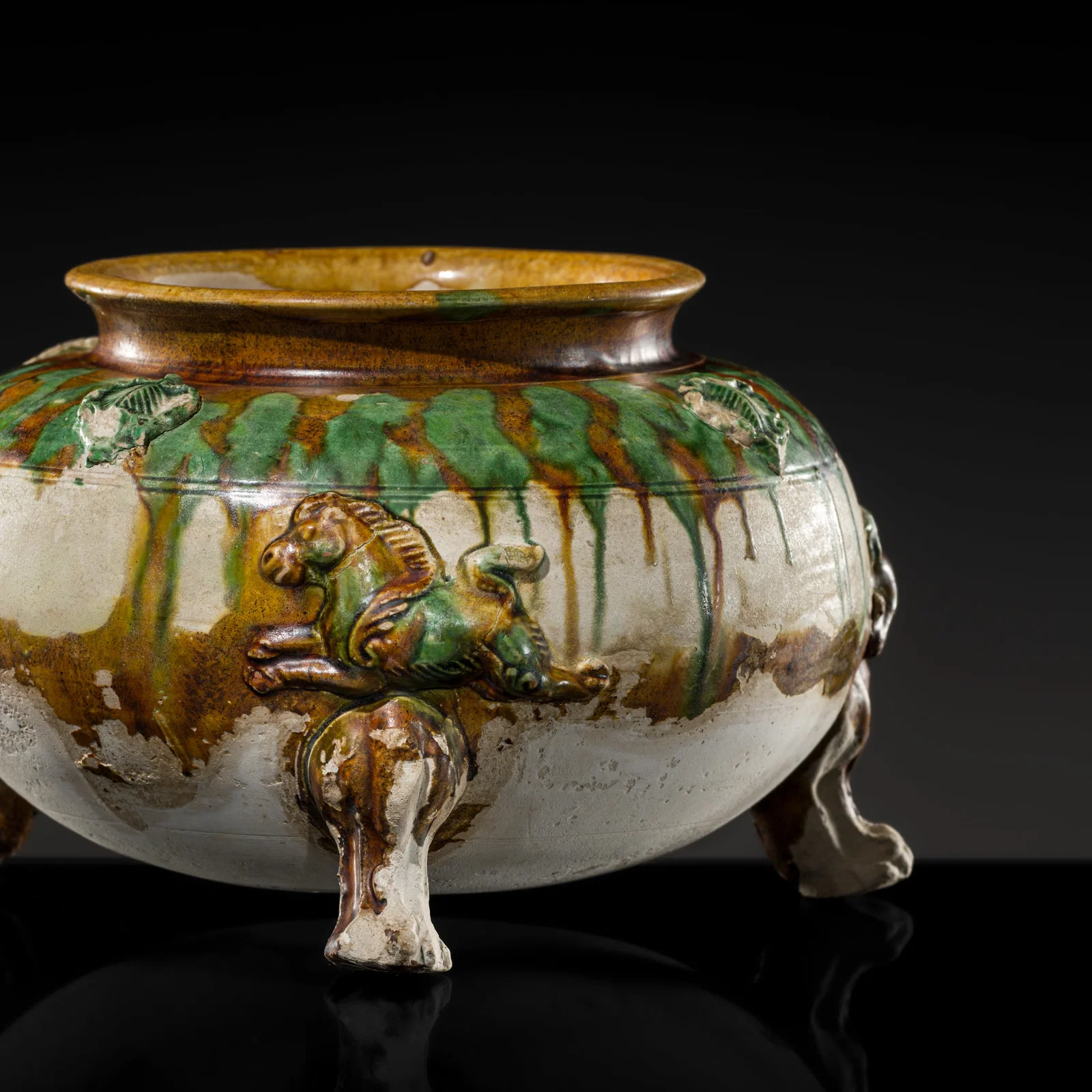 A SANCAI-GLAZED APPLIQUÉ-DECORATED TRIPOD JAR, TANG DYNASTY