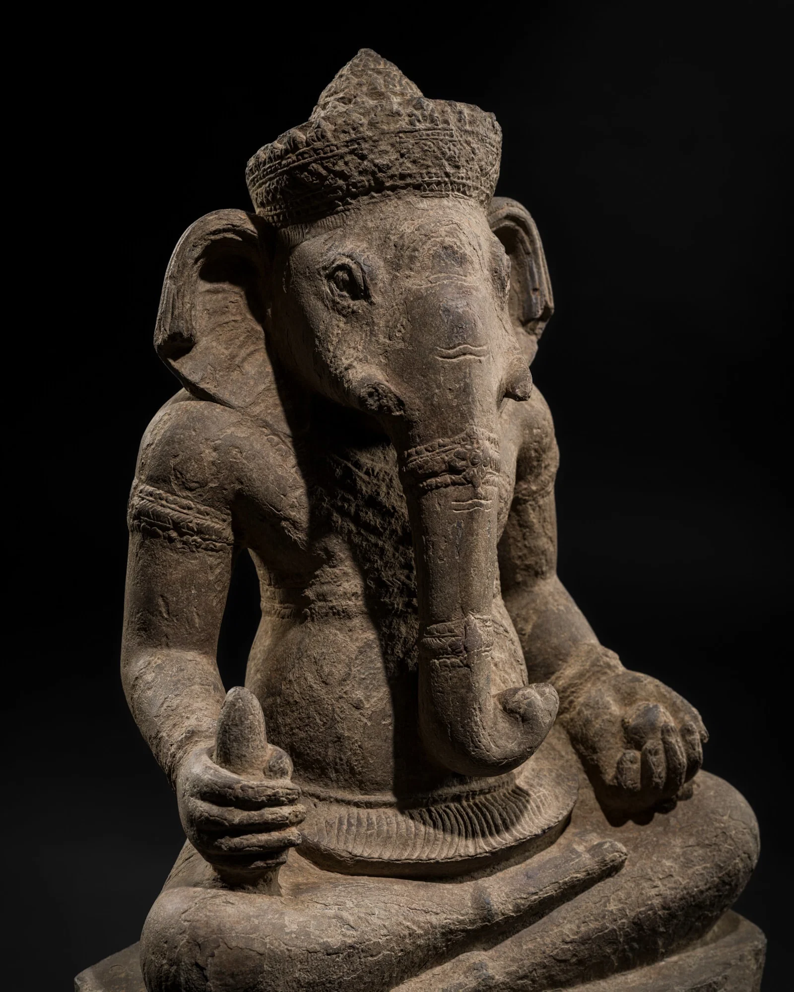 A SANDSTONE FIGURE OF GANESHA, ANGKOR PERIOD, ANGKOR WAT STYLE, 12TH CENTURY