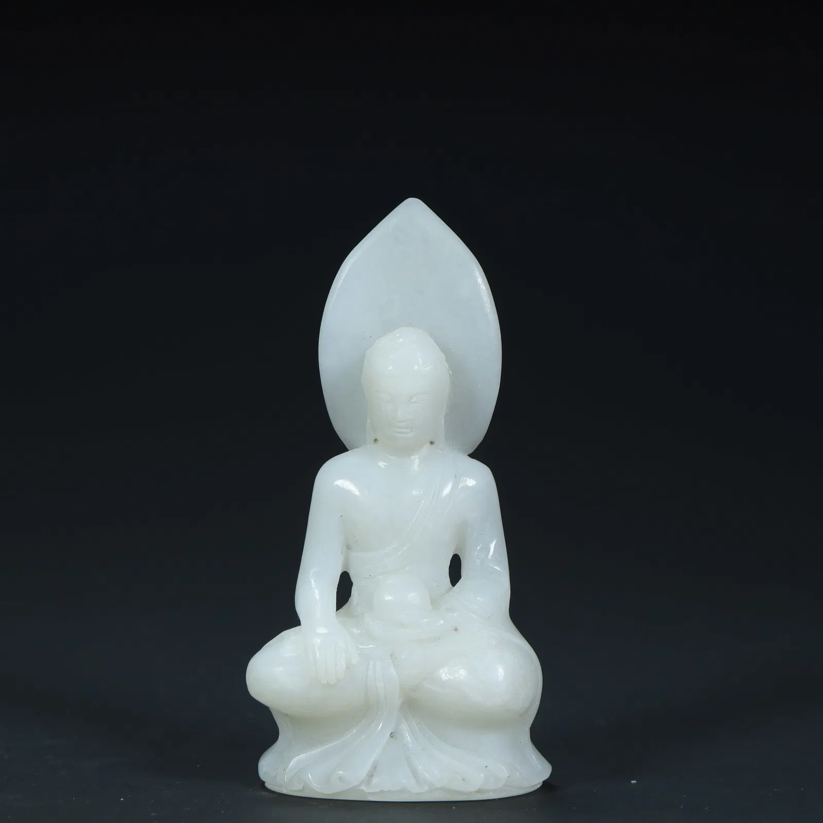 A seated statue of Shakyamuni Buddha carved in Hetian white jade in the Qing Dynasty