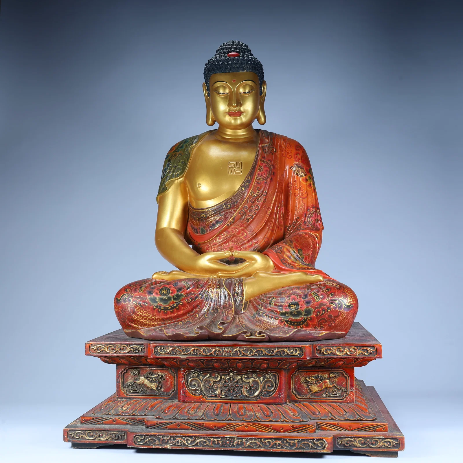 A seated statue of Shakyamuni Buddha painted in lacquered gold in the Qing Dynasty