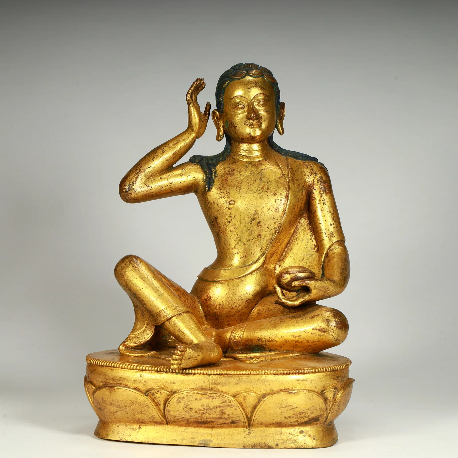A seated statue of Venerable Milarepa in bronze gilt in the Qing Dynasty