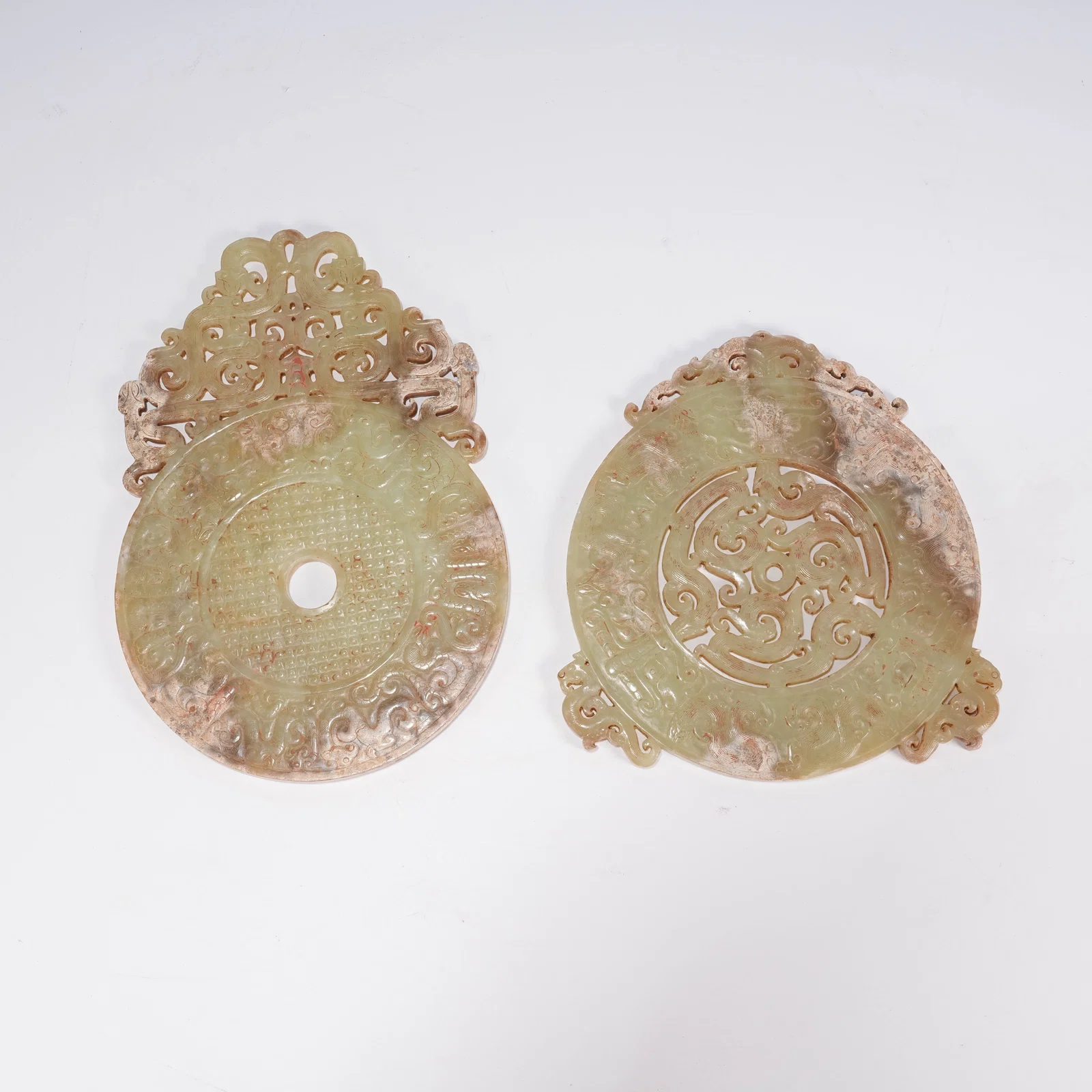 A SET OF ARCHAIC JADE BI DISCS WITH DRAGON MOTIFS AND OPENWORK EDGES