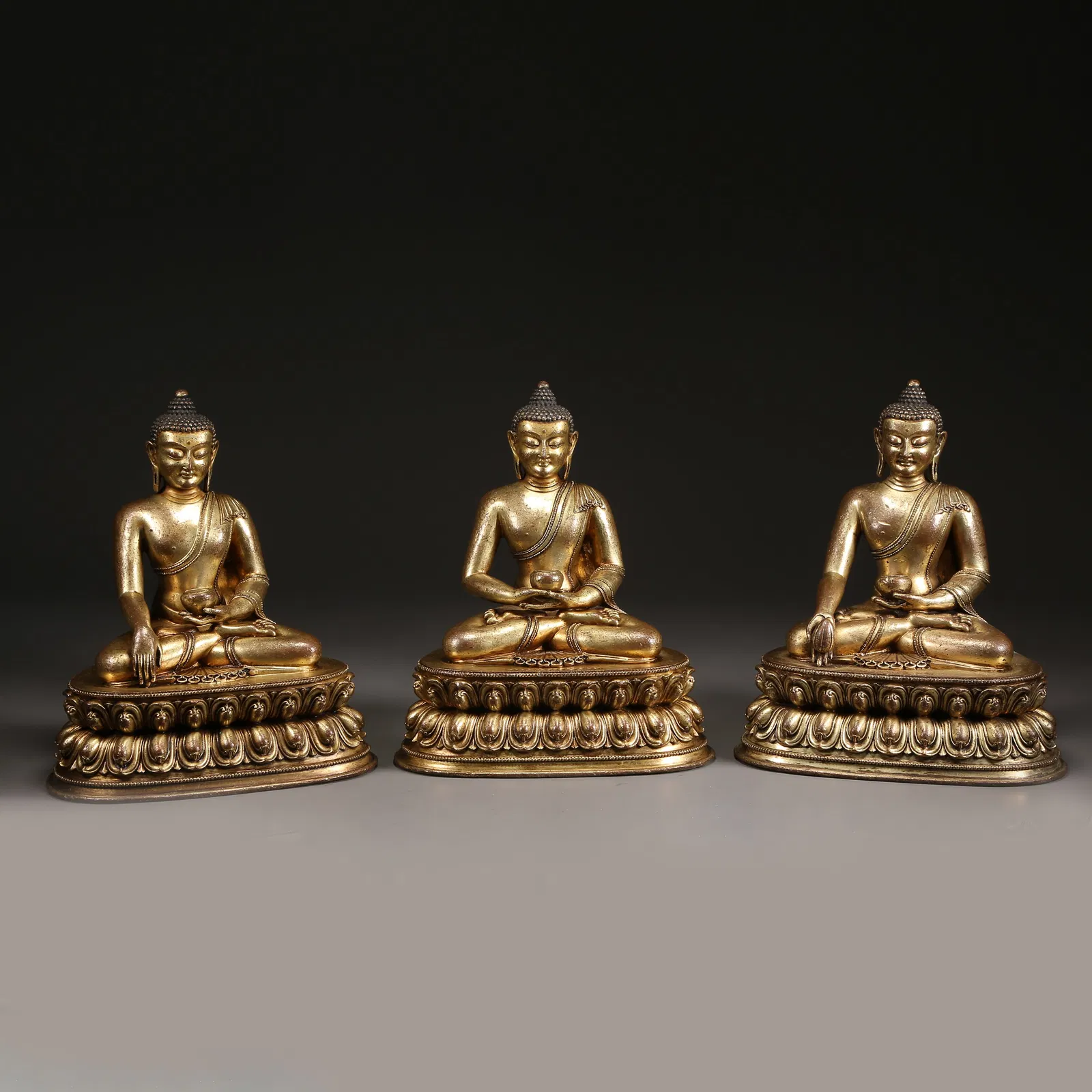 A SET OF GILT BRONZE BUDDHAS OF THE THREE AGES