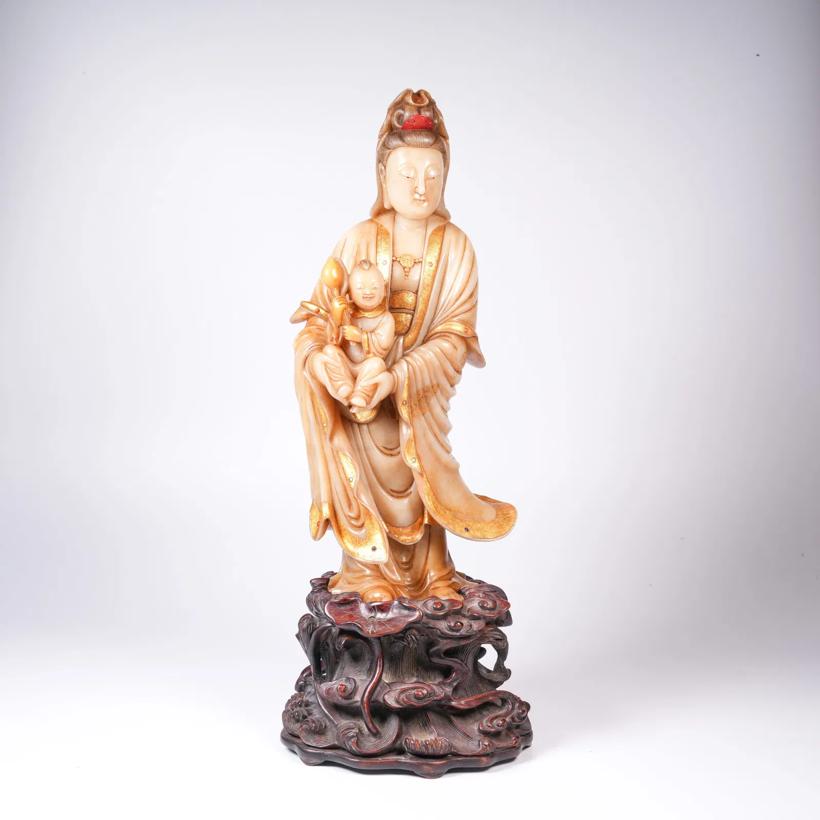 A SHOUSHAN STONE GILT INLAID STANDING GUANYIN OF CHILD-GIVING