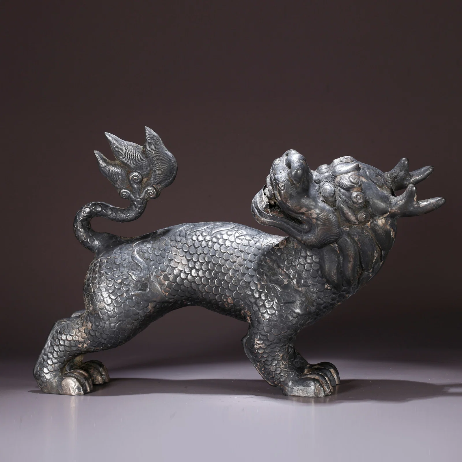 A SILVER QILIN-SHAPED ORNAMENT