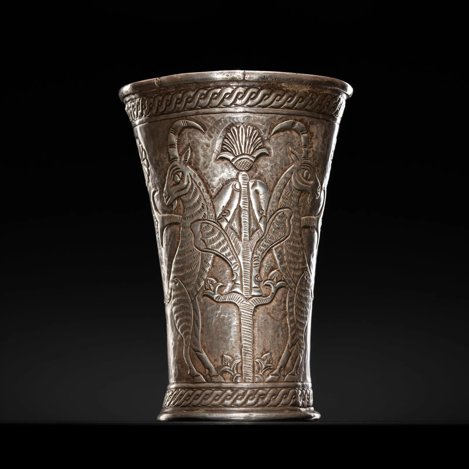 A SILVER REPOUSSÉ 'RAMPANT GOATS' BEAKER, ACHAEMENID EMPIRE, 550-330 BC