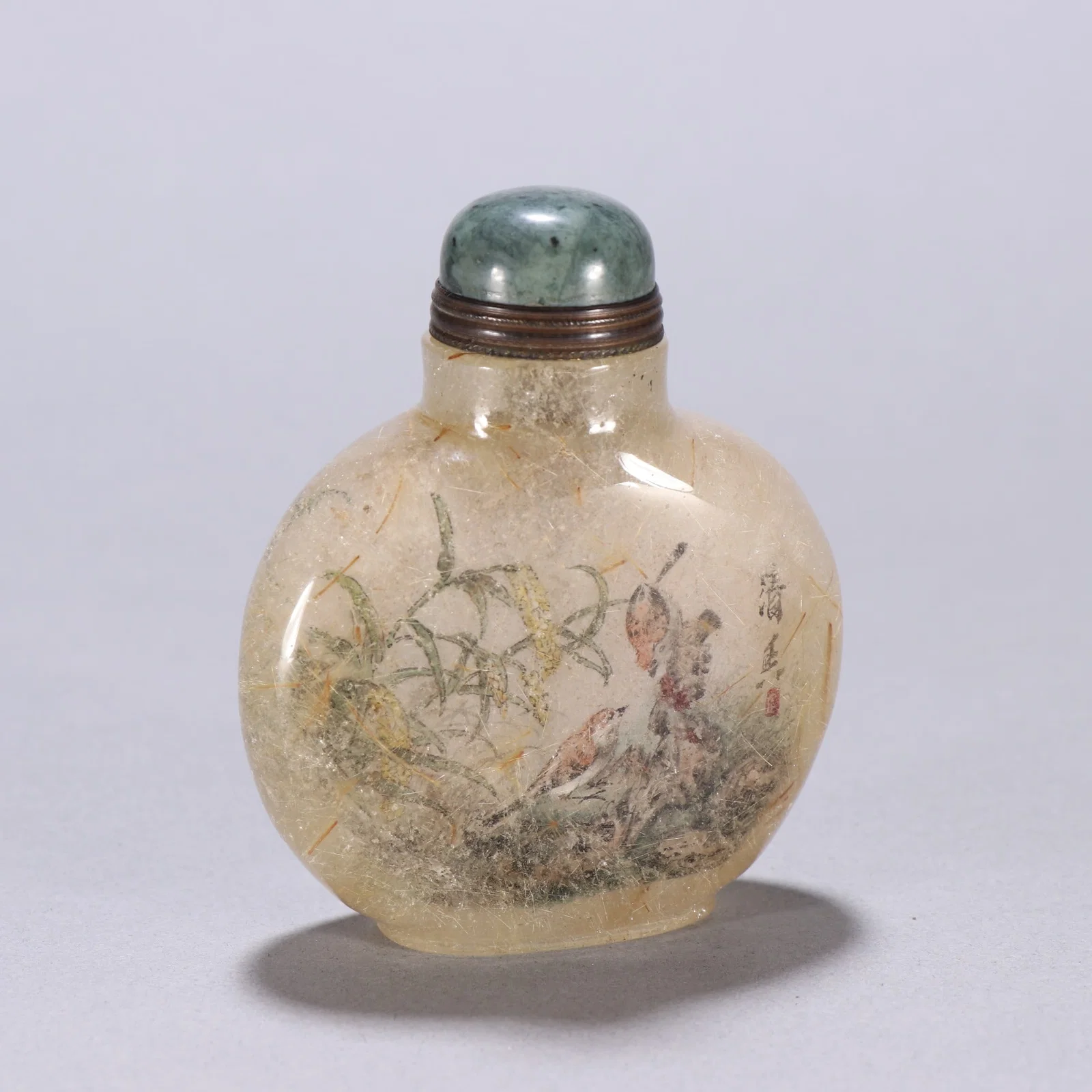 A snuff bottle with flower and bird patterns painted inside the hair crystal of the Qing Dynasty