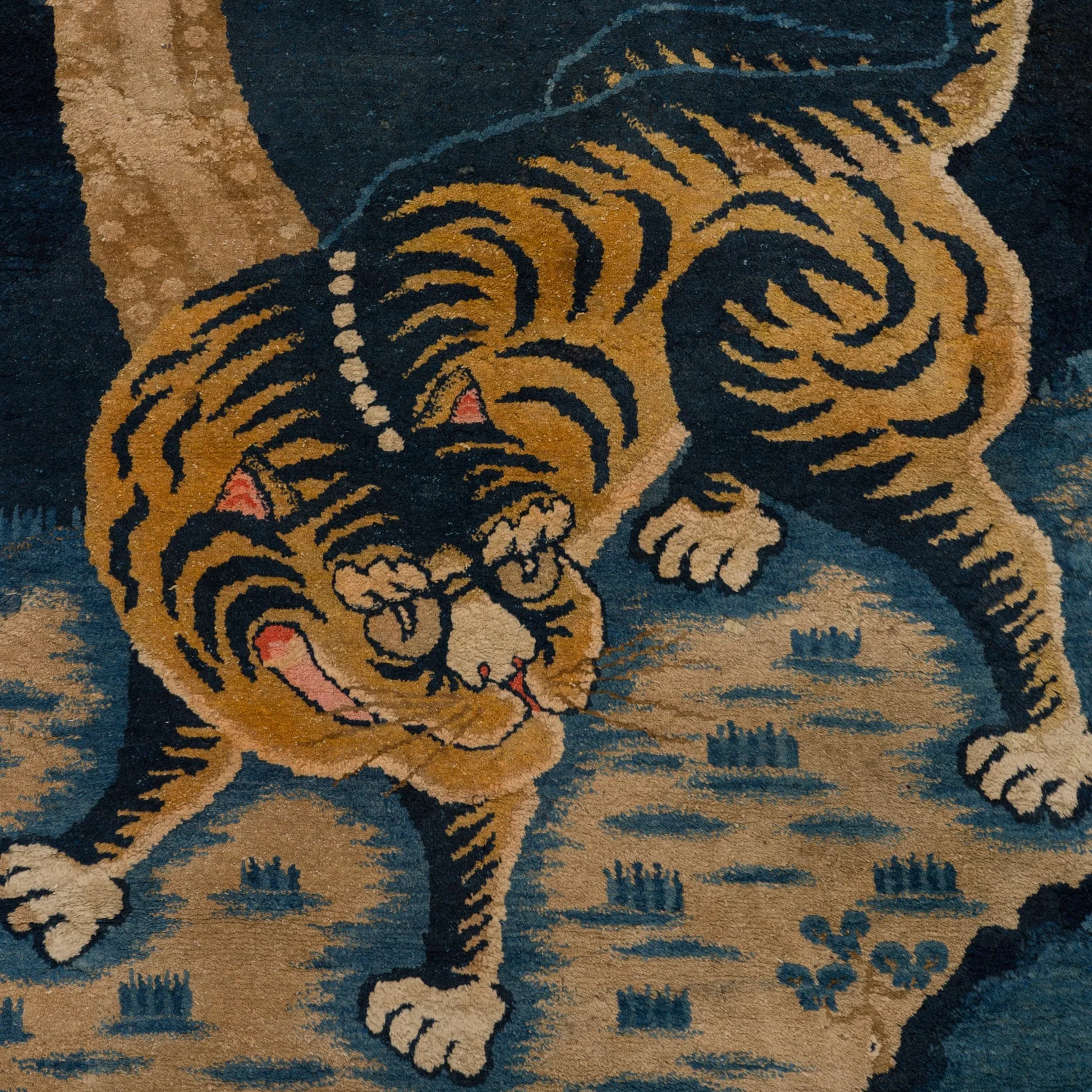 A 'STALKING TIGER' WOOL RUG, HIMALAYAN REGION, LATE 19TH TO EARLY 20TH CENTURY