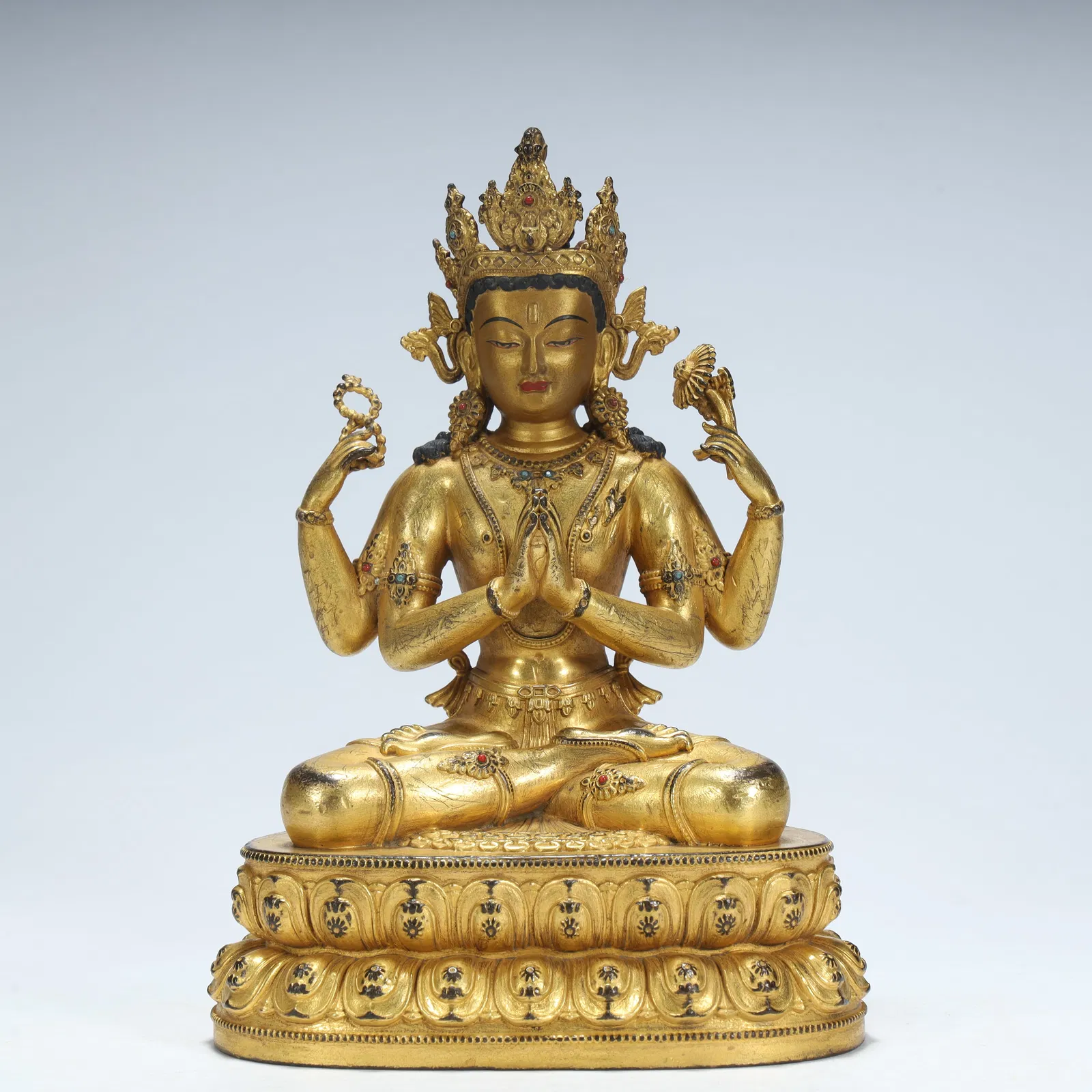 A statue of Guanyin with four arms in copper gilt in the Qing Dynasty