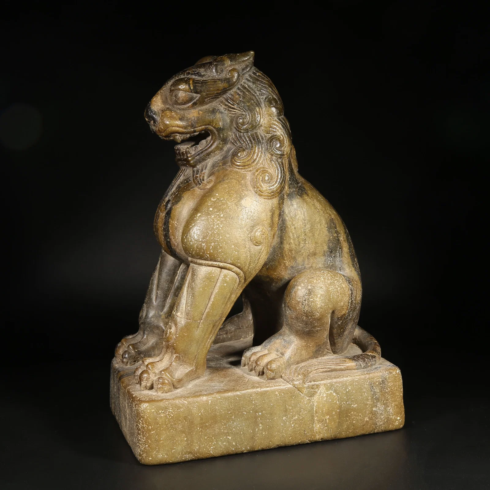 A STONE SEATED LION ORNAMENT