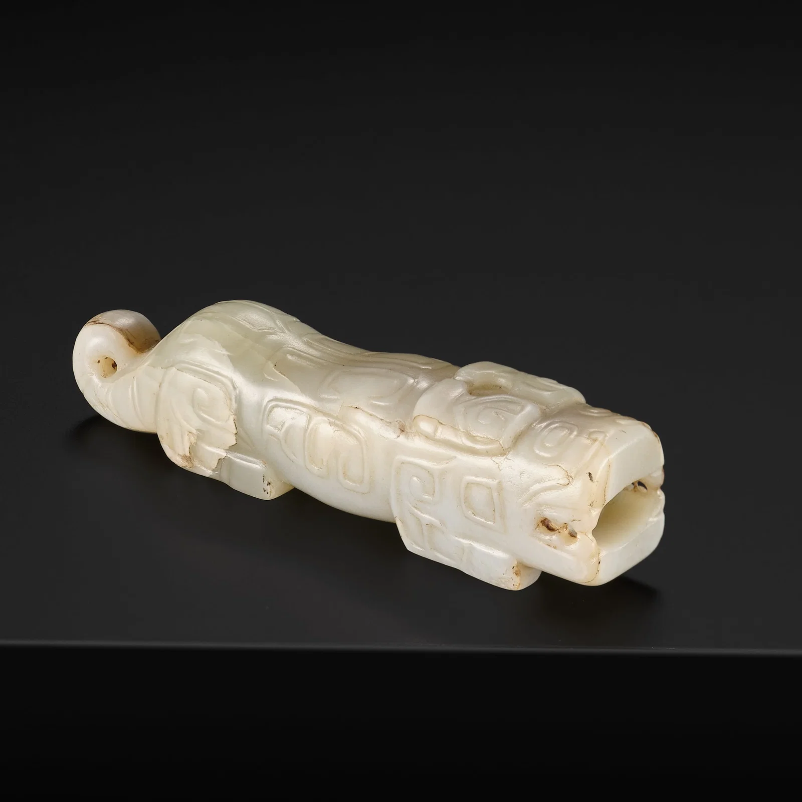 A SUPERB CELADON AND RUSSET JADE FIGURE OF A MYTHICAL TIGER, SHANG DYNASTY