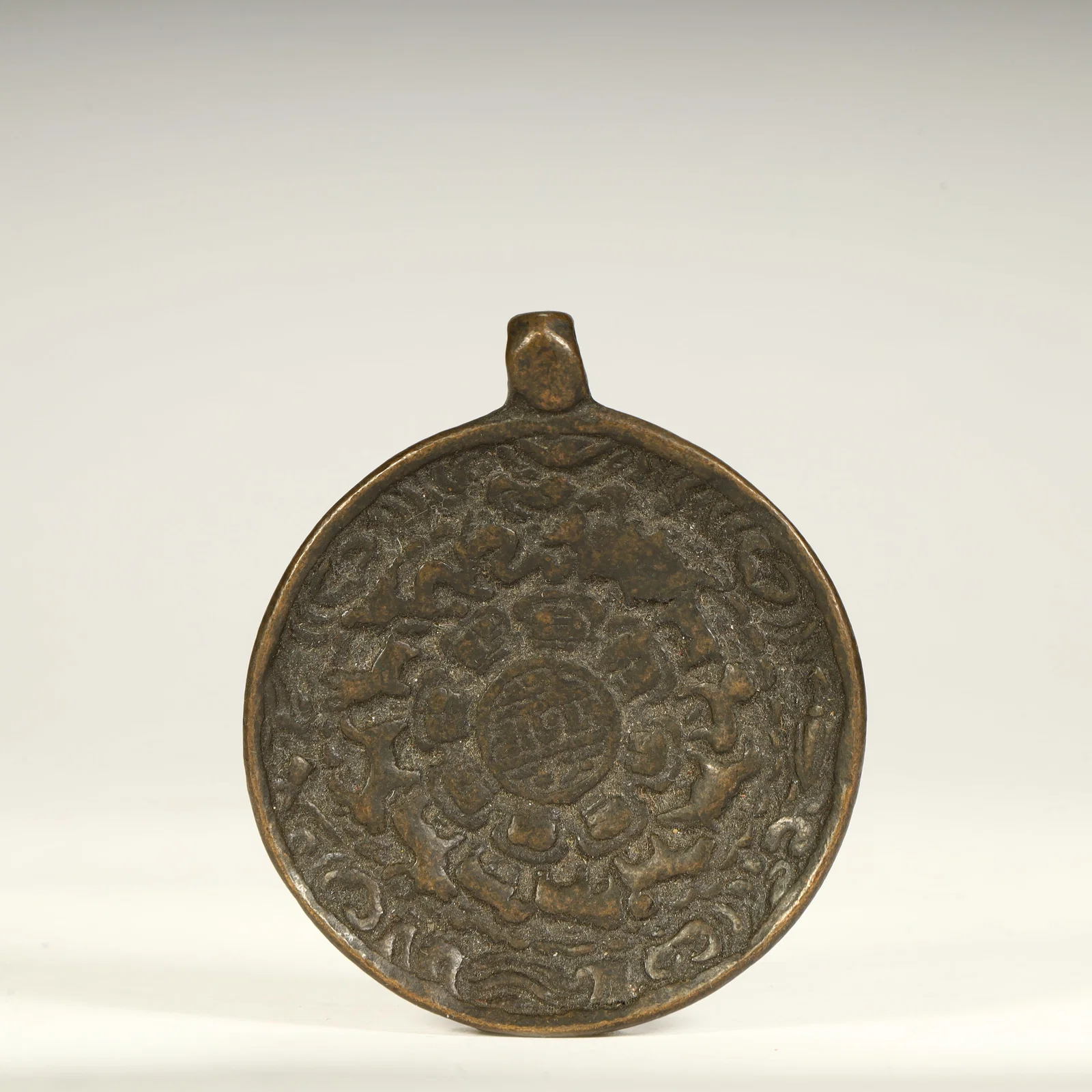 A Tang Dynasty bronze entwined pattern hanging mirror with handle