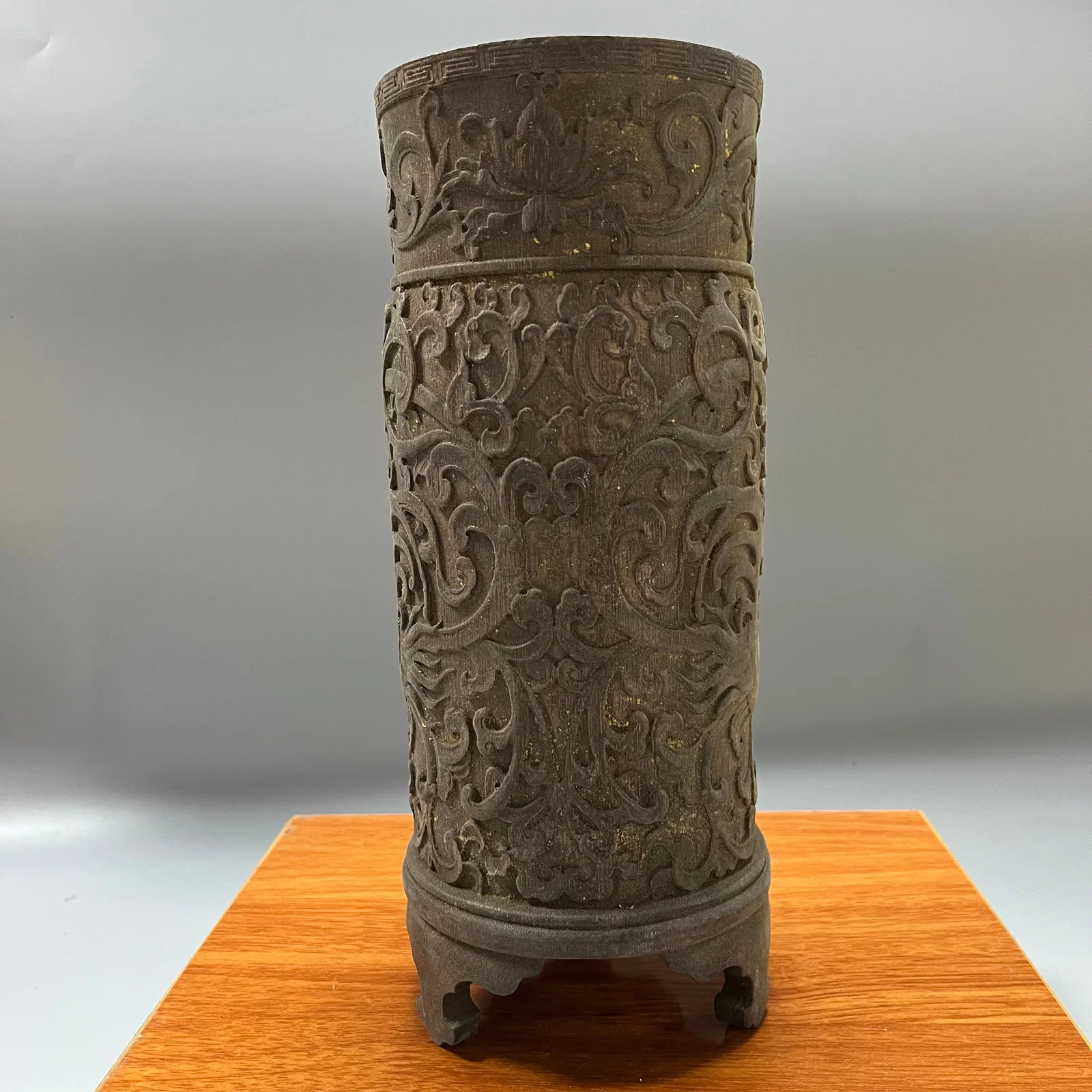 A three-legged brush pot with relief carving of dragons amidst lotus scrolls, dating from the