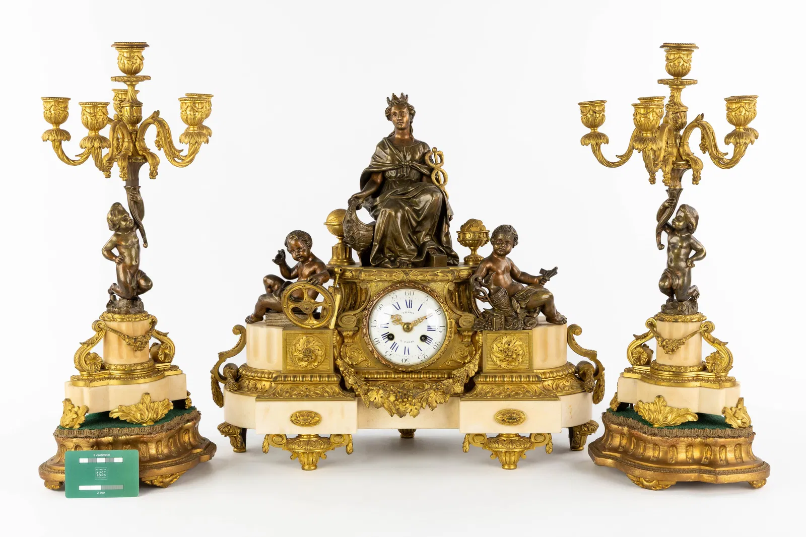 A three-piece garniture clock and candelabra, gilt bronze mounted on Carrara marble. Allegory of