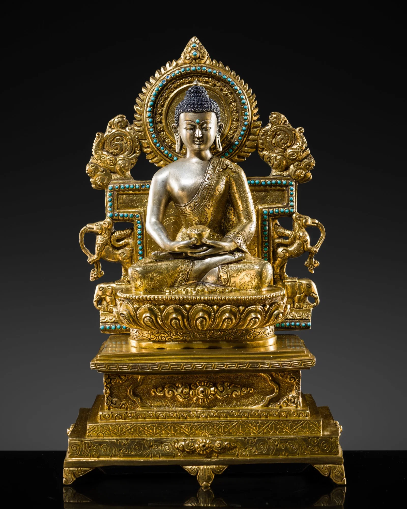 A TURQUOISE-INLAID GILT AND SILVERED COPPER ALLOY FIGURE OF THE ENTHRONED BUDDHA