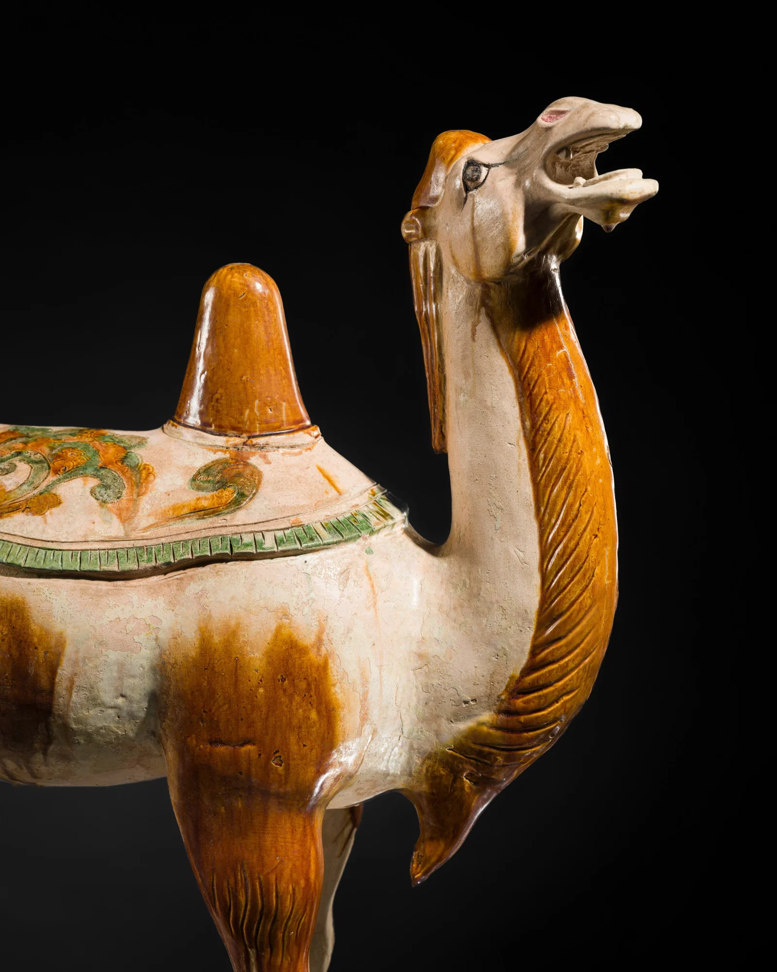 A VERY LARGE (71 CM) SANCAI-GLAZED AND INCISED POTTERY FIGURE OF A BACTRIAN CAMEL, TANG DYNASTY