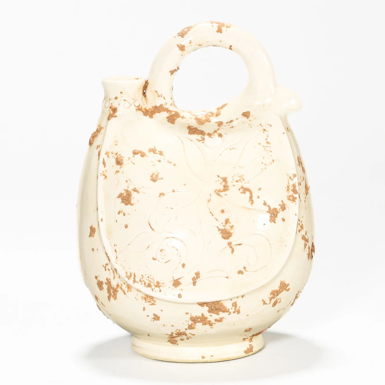 A WHITE-GLAZED CARVED SKIN-FORM EWER.