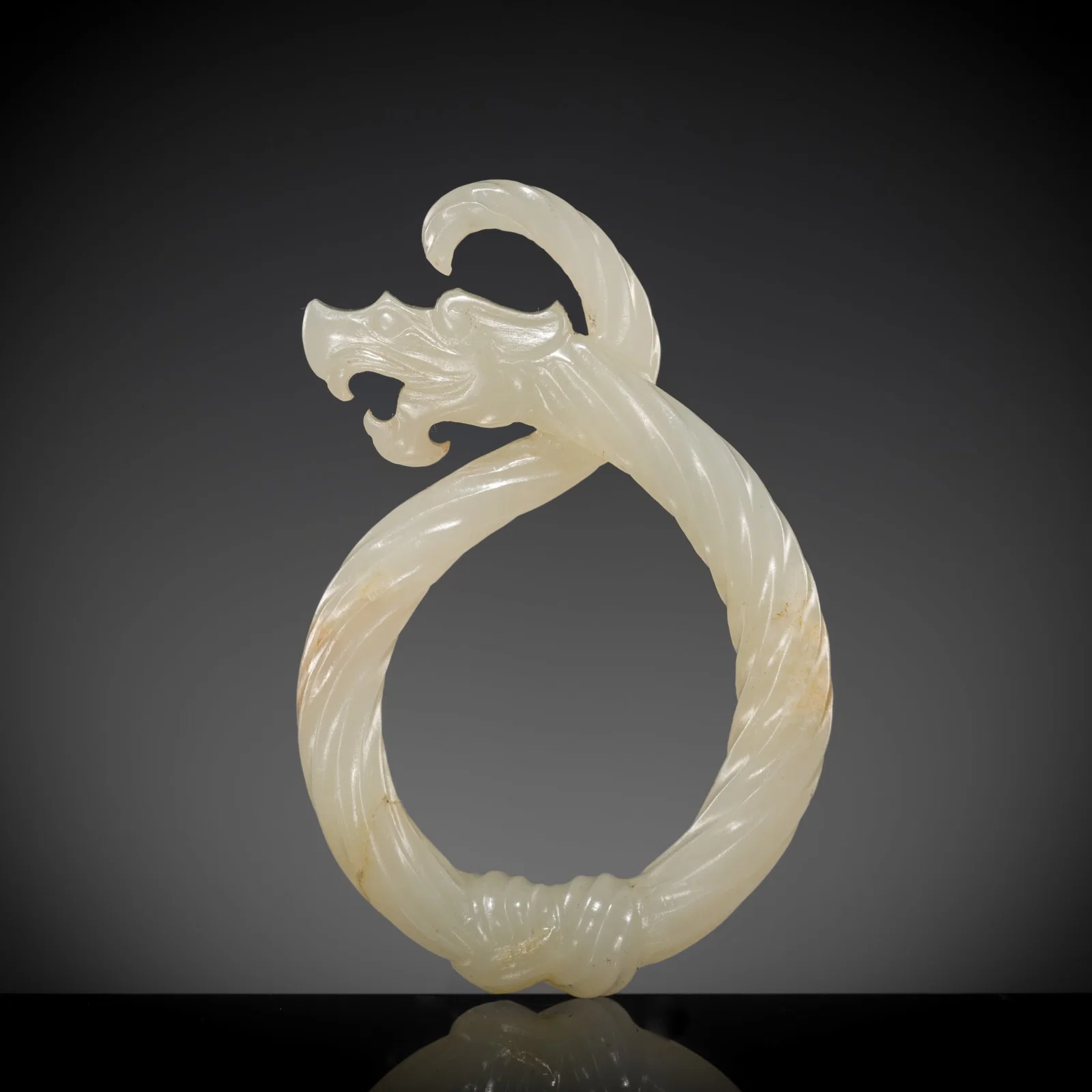 A WHITE JADE 'KNOTTED DRAGON' PENDANT, LATE WARRING STATES PERIOD