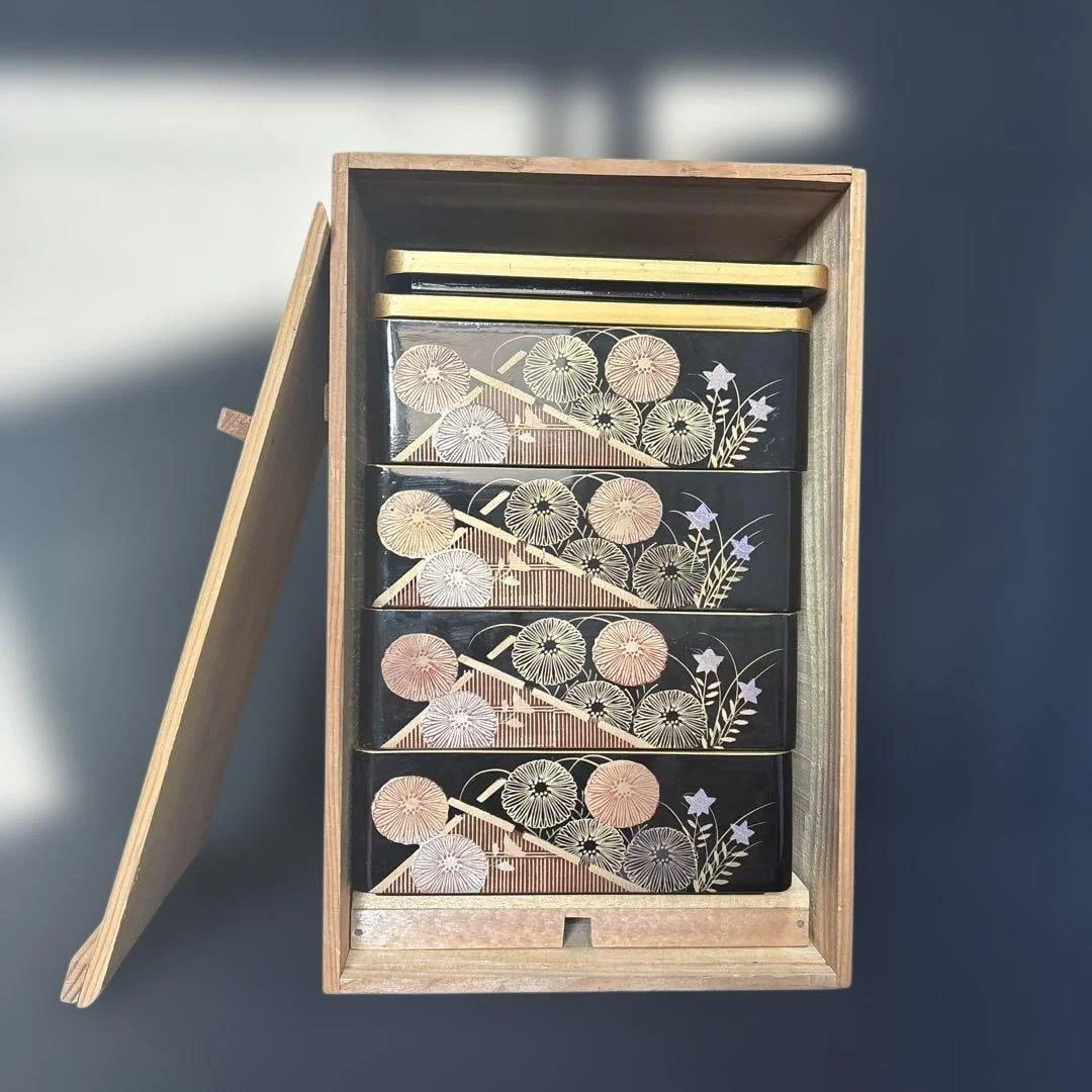 A wooden lacquered bento box, adorned with chrysanthemum motifs and maki-e (gold lacquer)