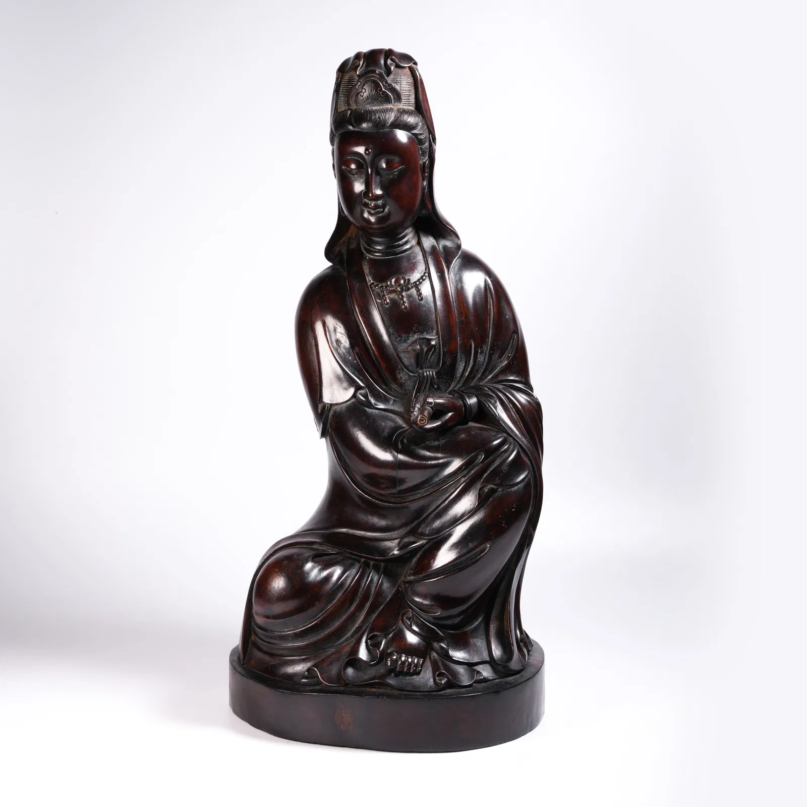 A ZITAN GUANYIN HOLDING A SCROLL STATUE